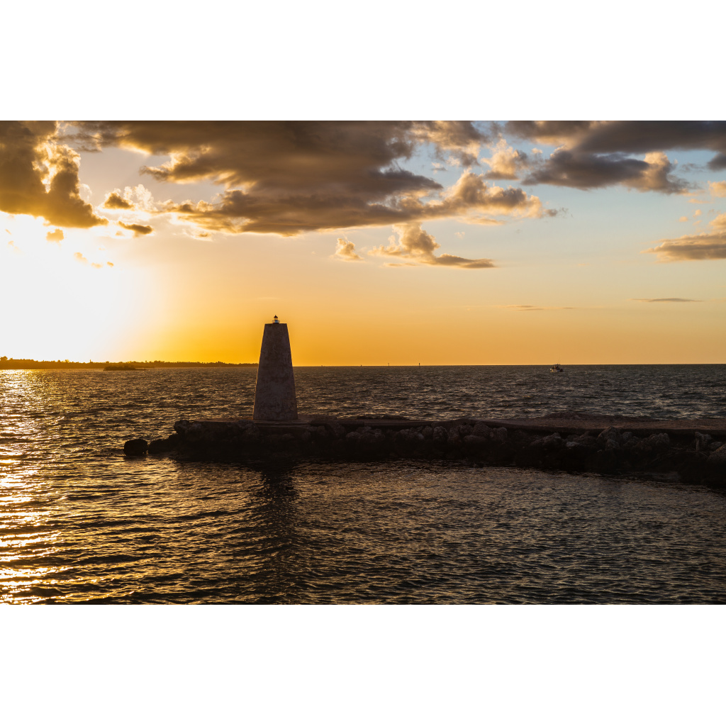 Harbor beacon glowing at golden hour along the Florida Keys shoreline.