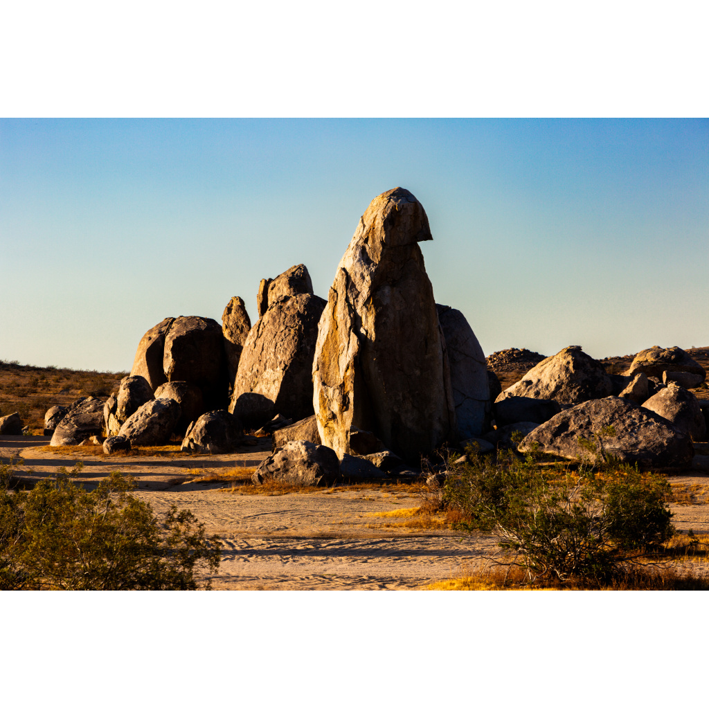 Golden hour light casting shadows across sculpted desert boulders in the American Southwest.