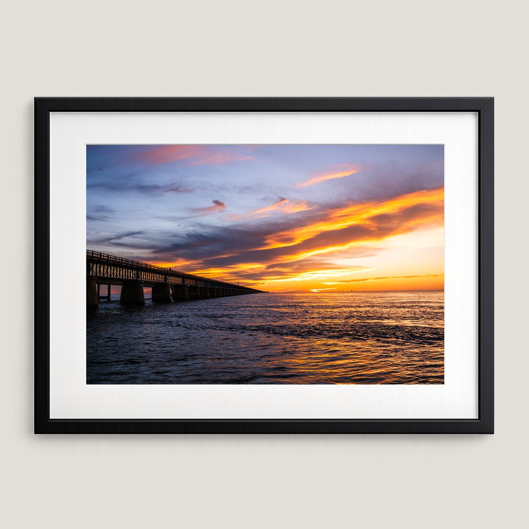 Fine art print of Seven Mile Bridge at sunset in black wood frame with white mat board.