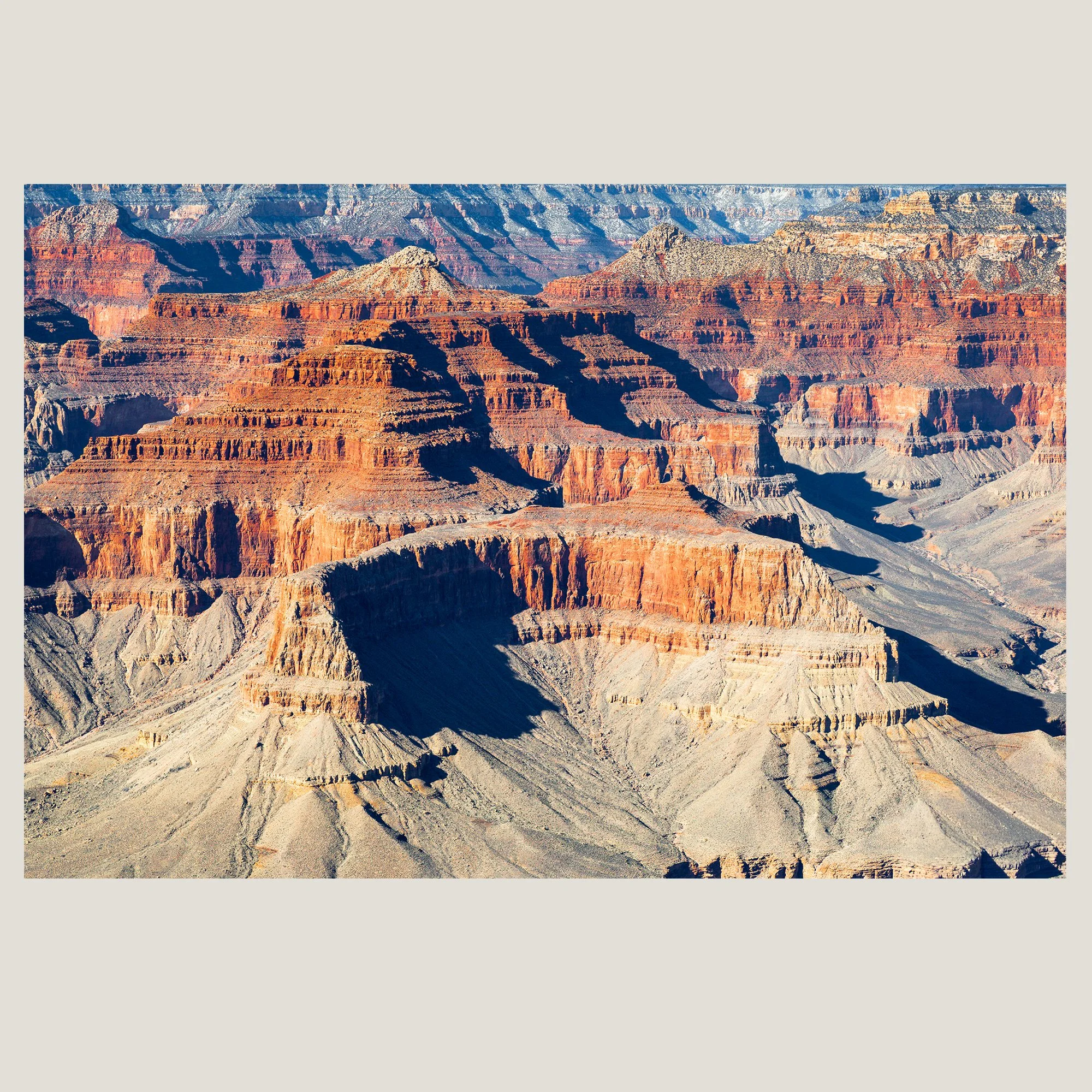 Layered sandstone mesas and buttes illuminated by desert light in the Grand Canyon, Arizona.