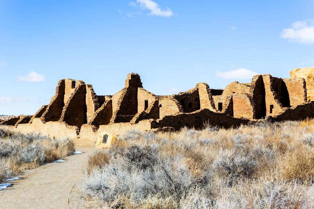 Ancient stone structures and walls of Chaco Canyon ruins beneath a clear New Mexico sky.