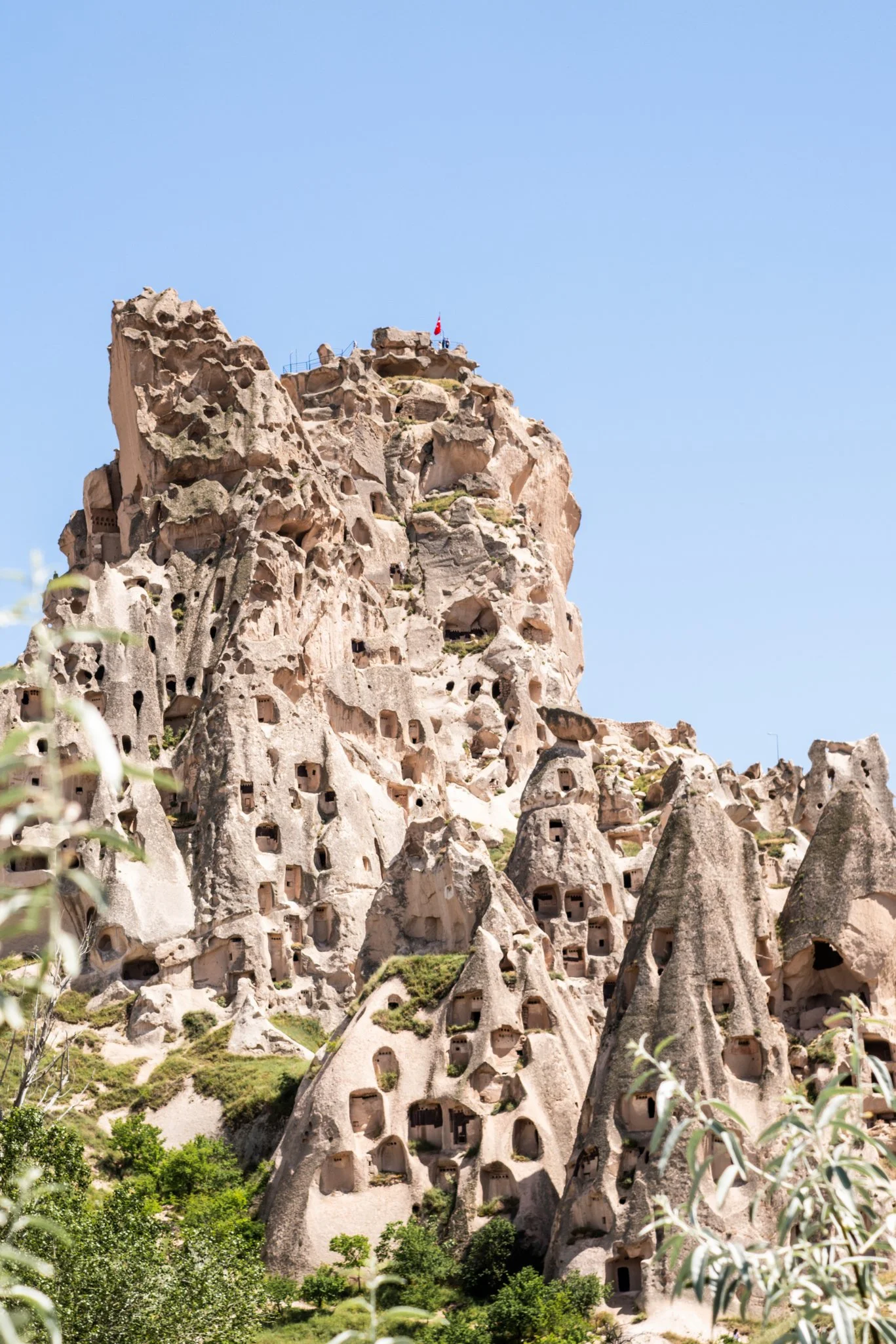 Fine art photography print of Ancient rock dwellings carved into stone cliffs in Uçhisar, Cappadocia, Turkey.