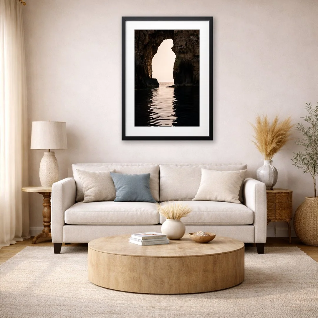 Navagio sea arch coastal wall art displayed above sofa in warm neutral living room