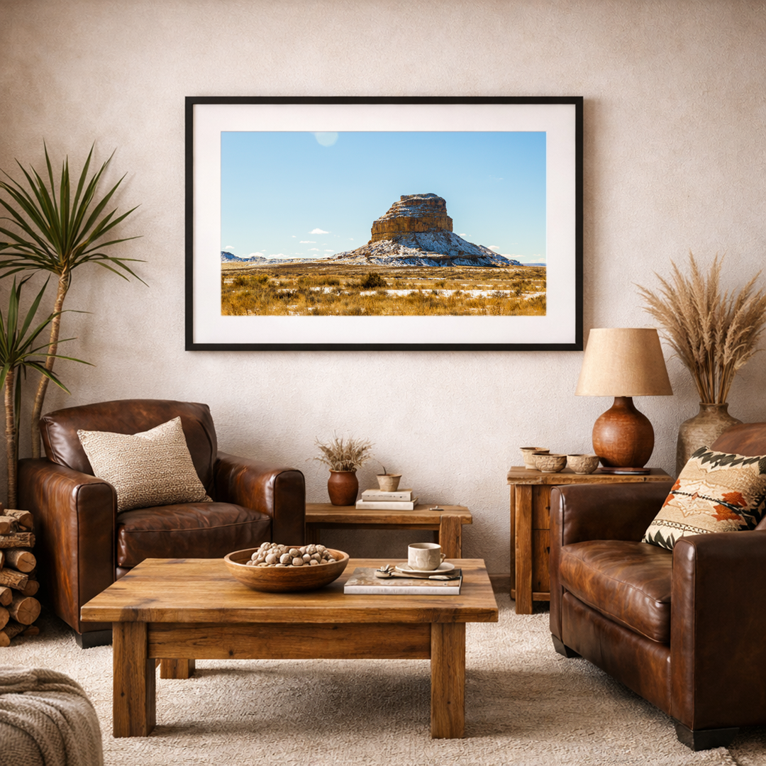 Snow-dusted desert butte fine art print displayed in a modern, neutral-toned living room interior.