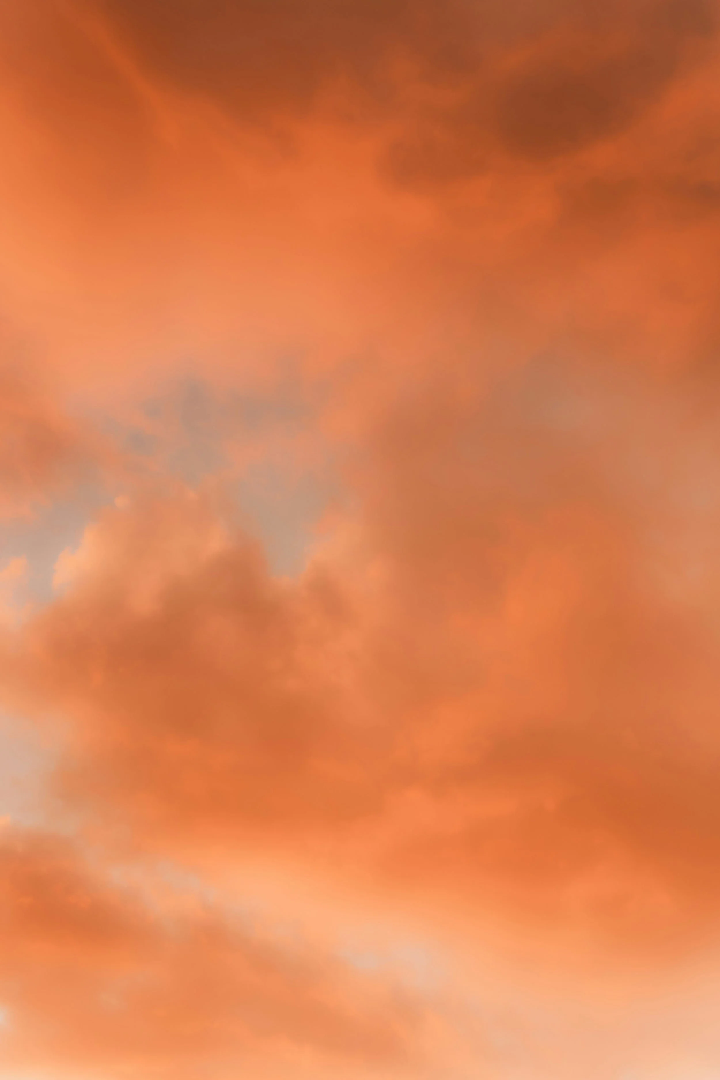 Orange and pink clouds in a sky, possibly during sunset or sunrise.