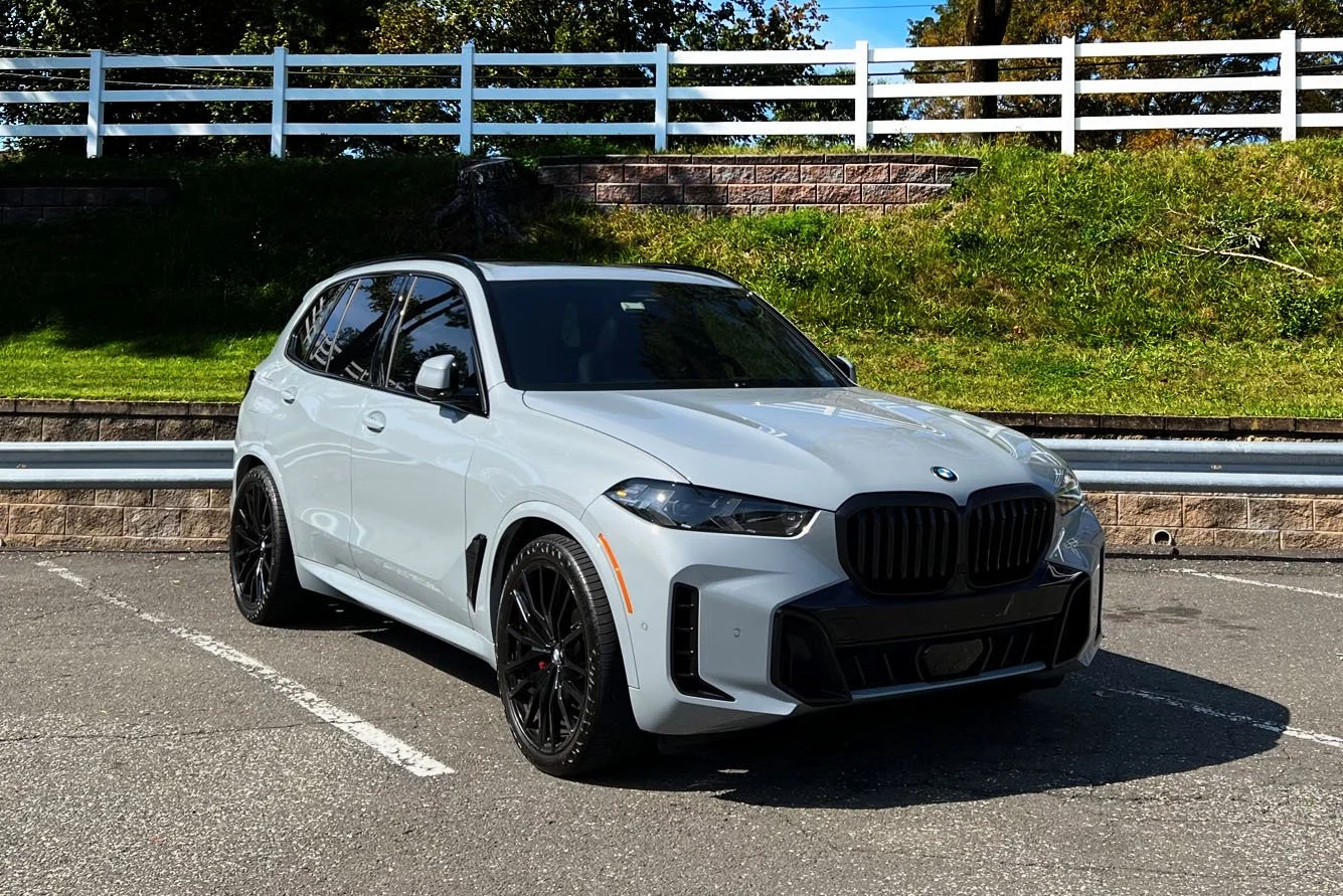 White BMW SUV parked in a sunny parking lot.