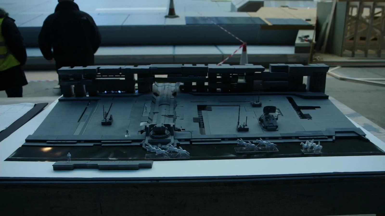 Architectural model of a building with surrounding streets and miniature figures.