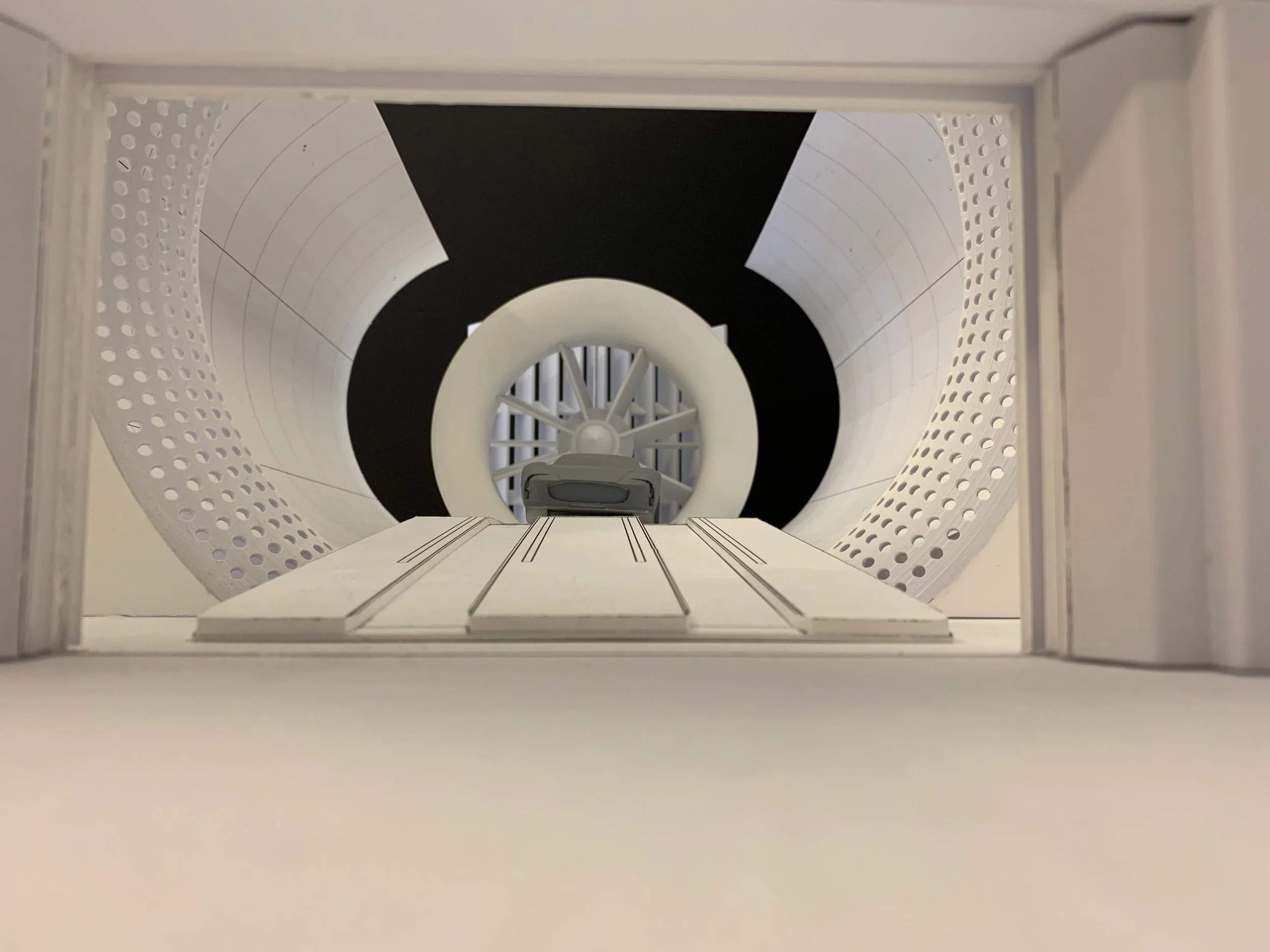 Inside an MRI machine, with a gray patient table in the center and a circular opening with a black and white pattern surrounding it.