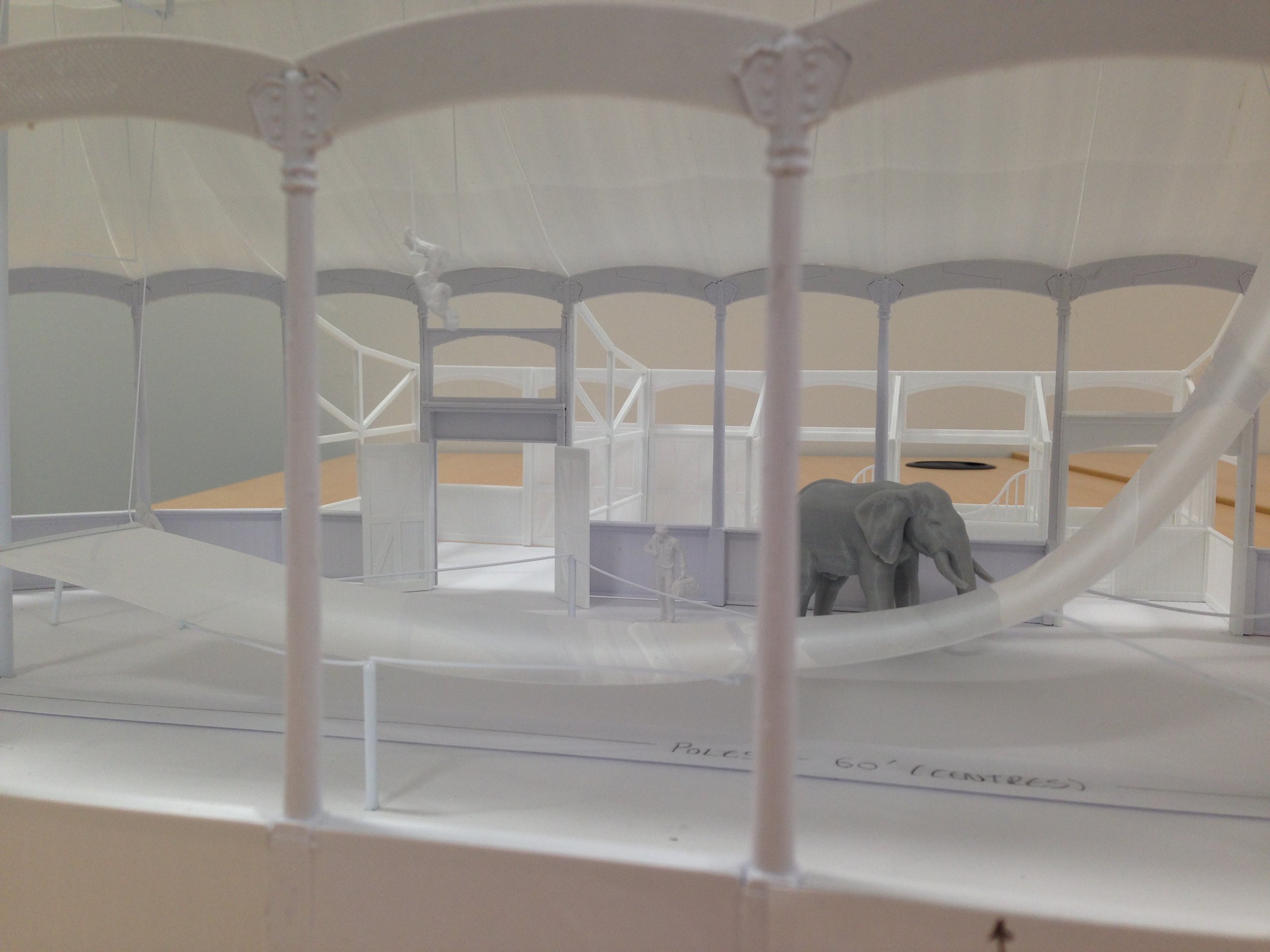 A detailed model of a circus tent structure with an elephant figurine inside.