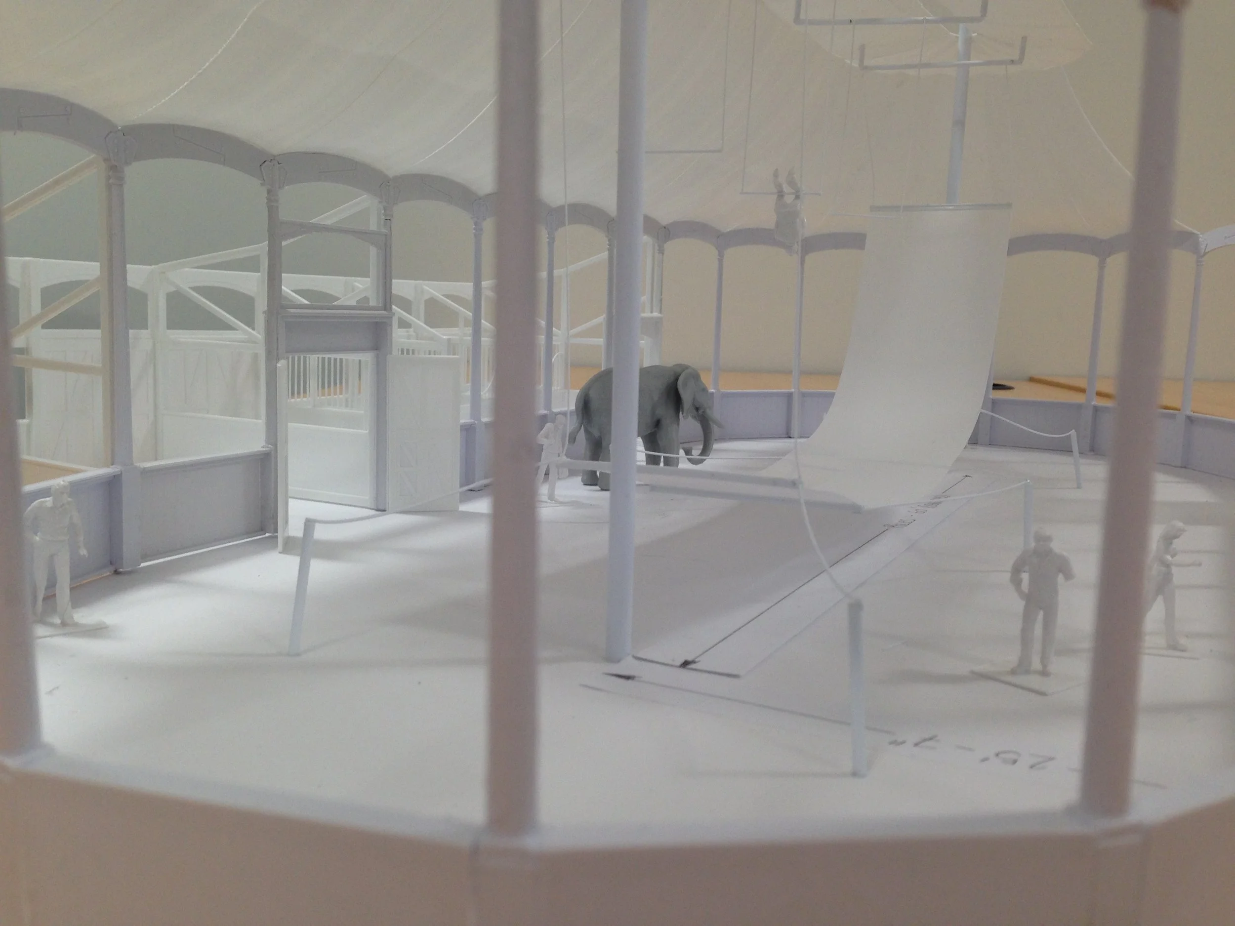 Architectural model of a circus arena with a big top tent, an elephant, and figurines of people.