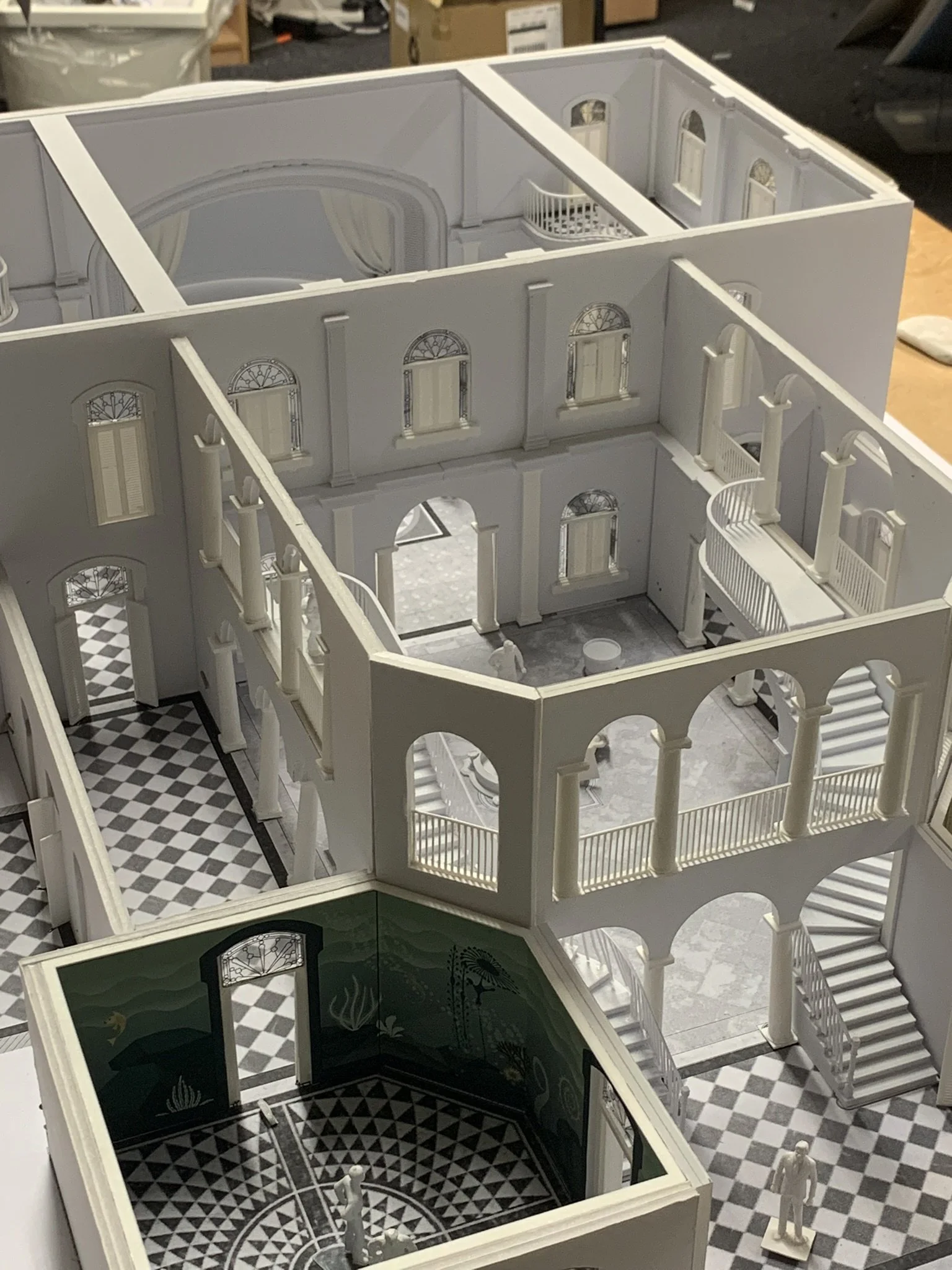 Detailed model of a historic mansion or palace with multiple floors, ornate windows, staircases, and a patterned floor in some rooms.