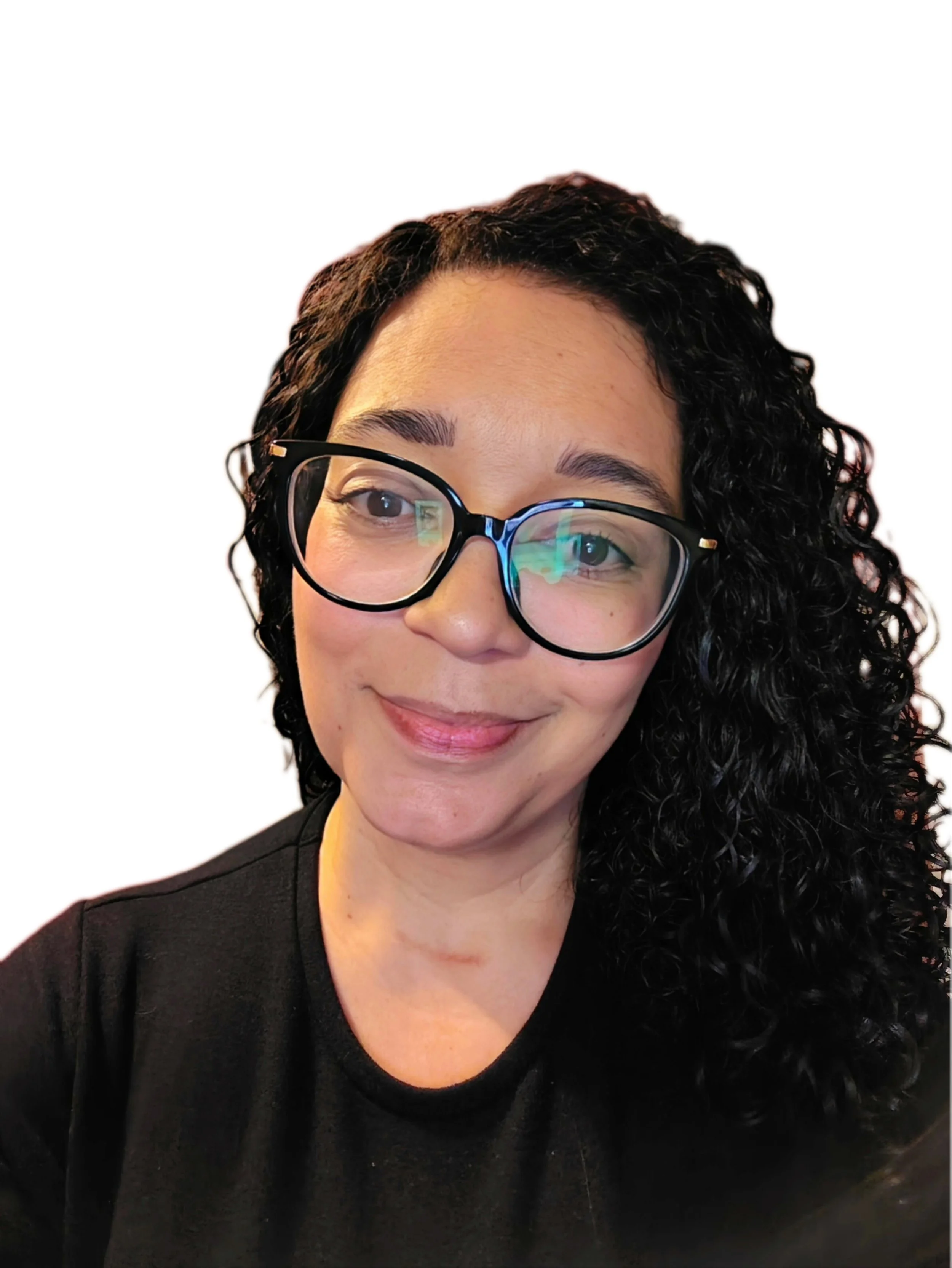 A woman with long curly black hair wearing glasses and a black top, smiling, with a plain white background.