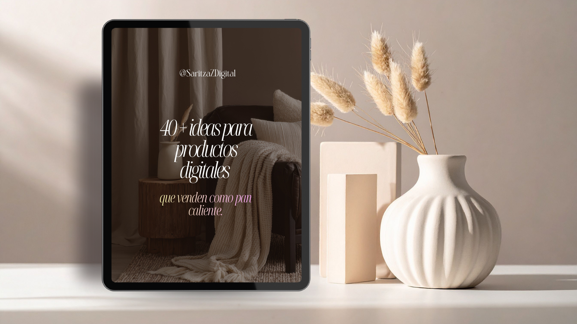 Pantalla de tableta mostrando un texto que dice '40+ ideas para productos digitales que venden como pan caliente', al lado de una vasija blanca con flores secas en un ambiente neutro y minimalista.