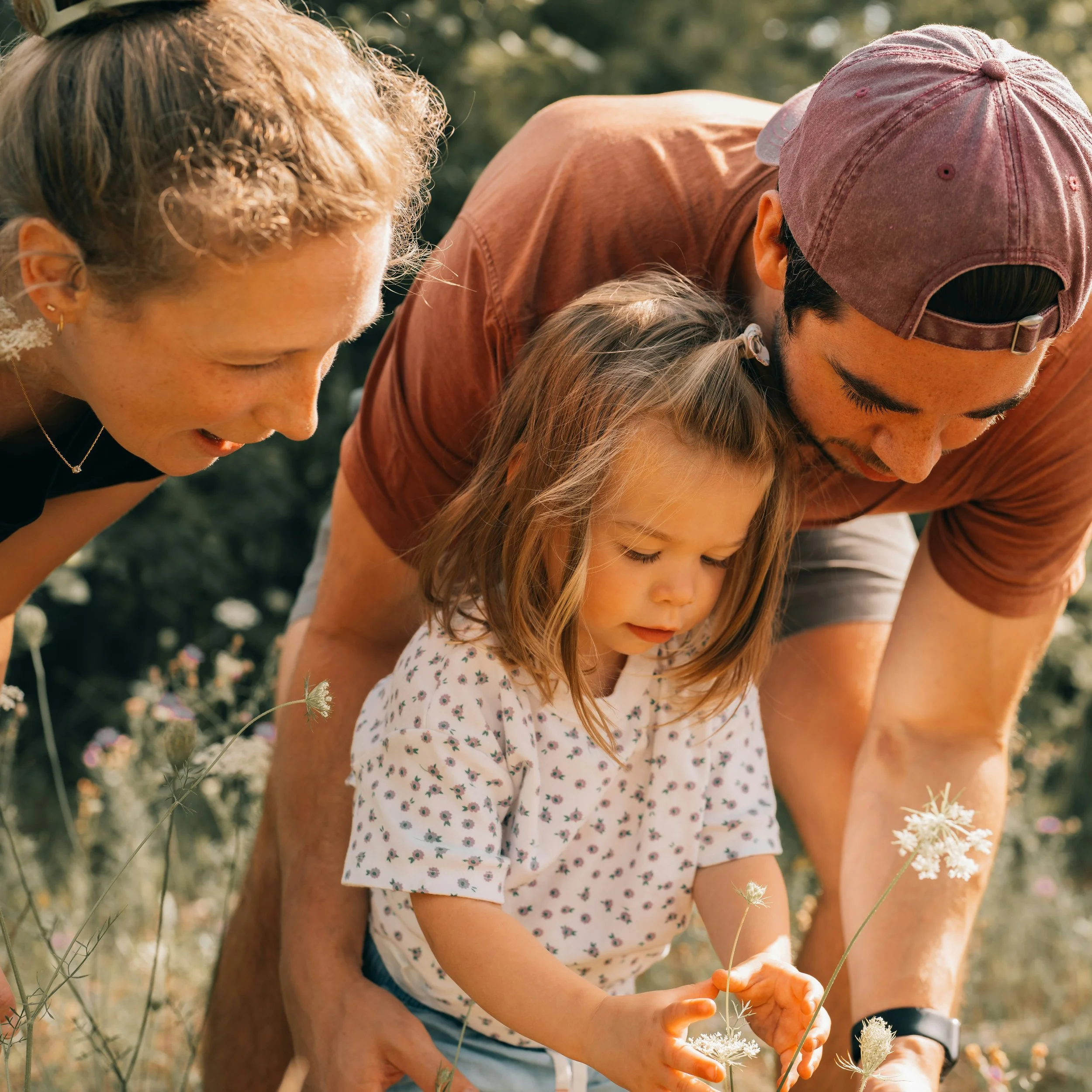 Eine junge Familie entdeckt Pflanzen im Freien an einem sonnigen Tag