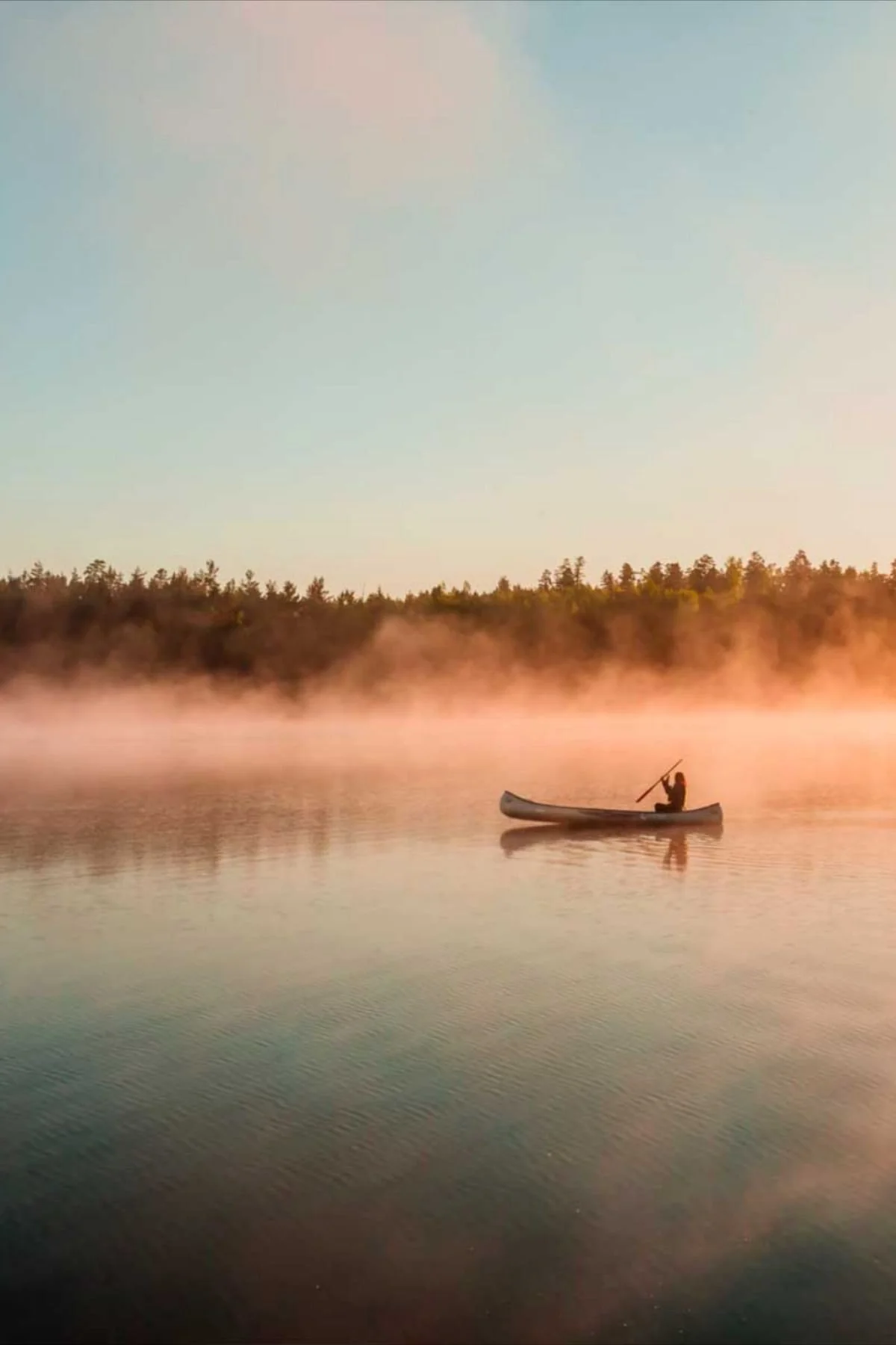 A person with his canoe in the middle of a river