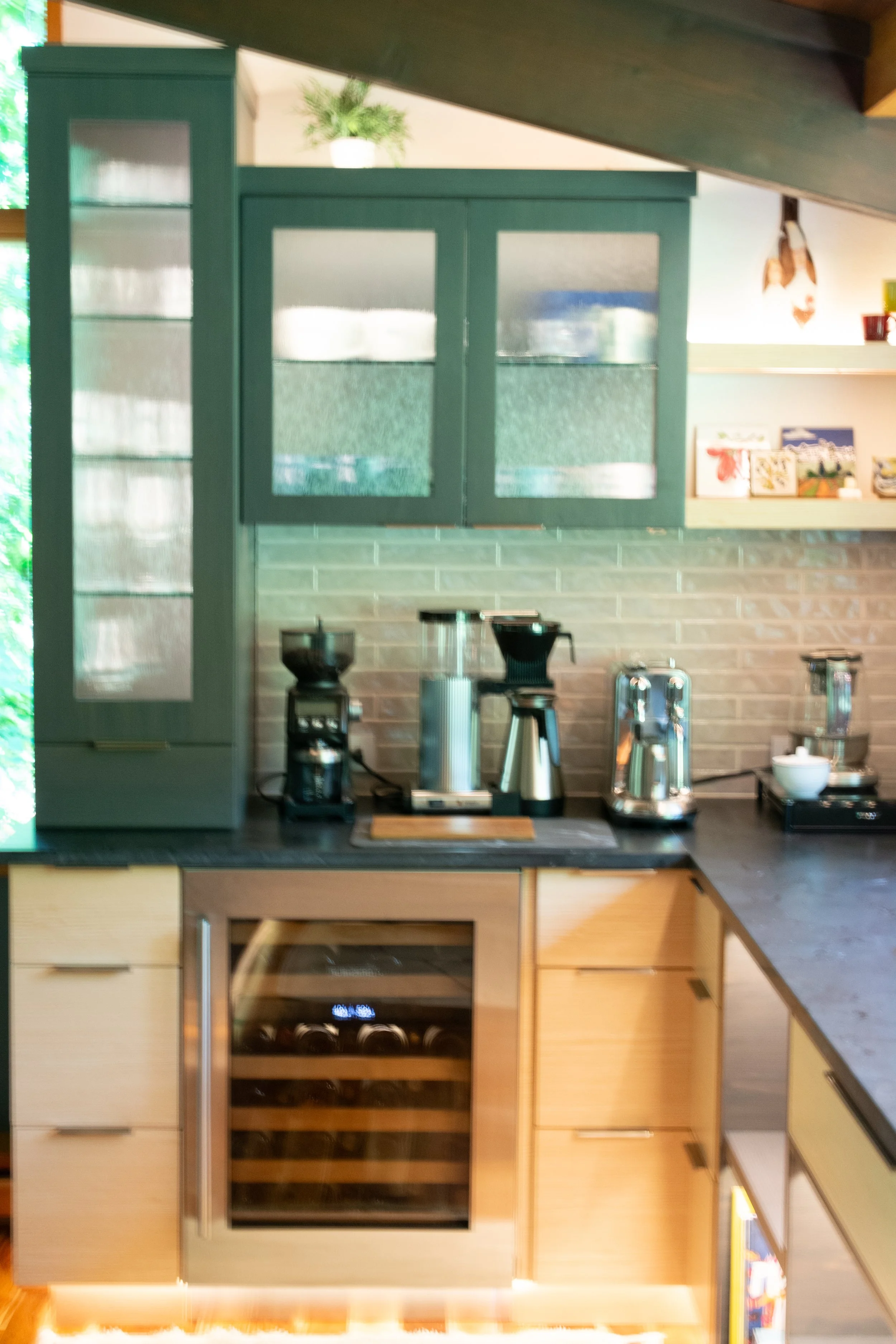 Kitchen with coffee-making appliances, wine cooler, cabinets, and countertop.