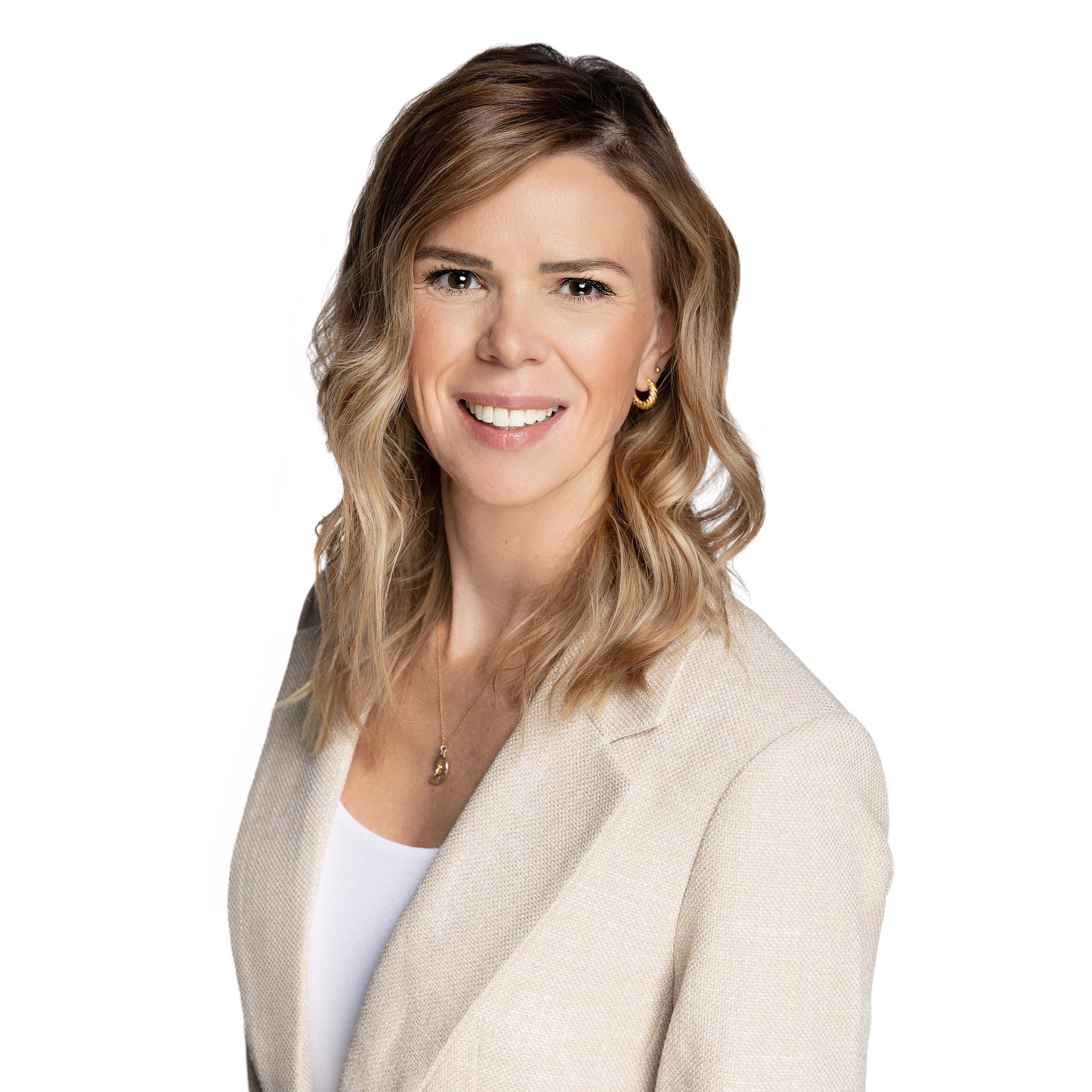 Professional woman with wavy blonde hair wearing a beige blazer, white top, earrings, and a necklace, smiling against a white background.