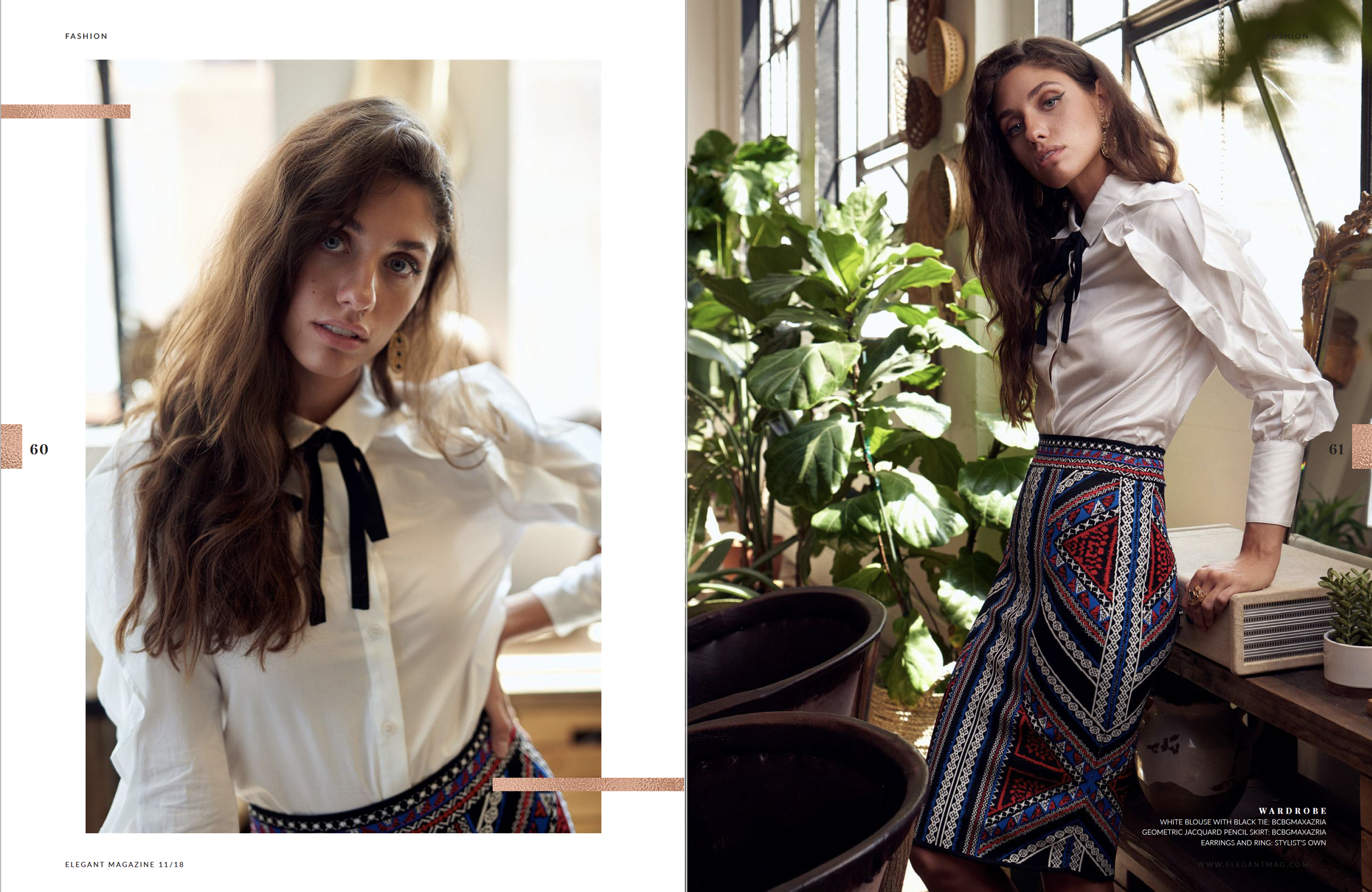 A woman with long wavy brown hair wearing a white blouse with a black ribbon tie and a colorful geometric patterned pencil skirt, posing in front of lush green plants and a large window with natural light.