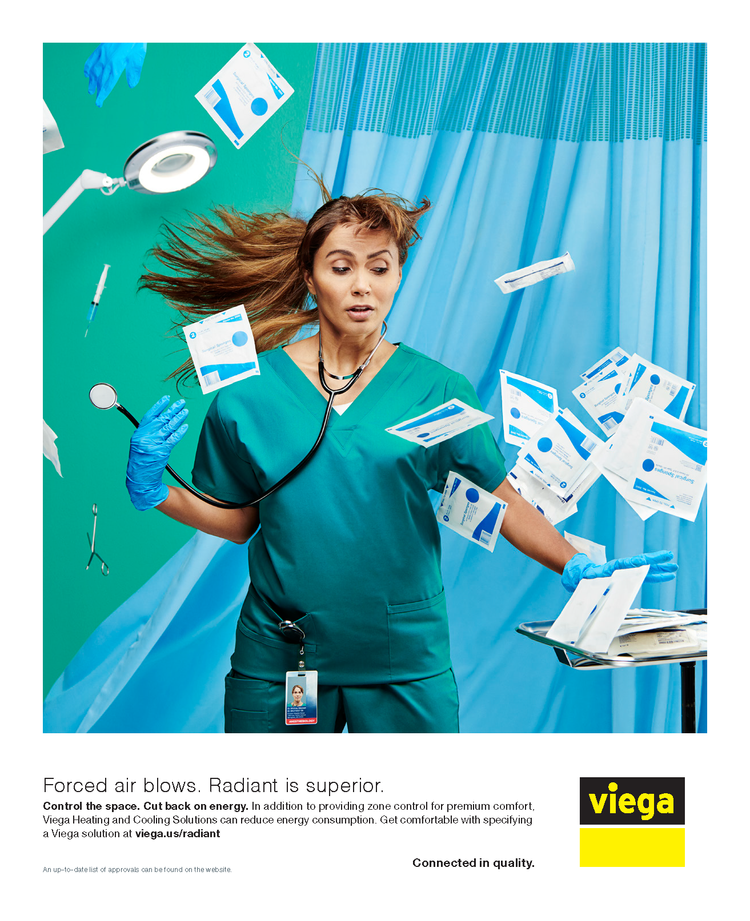 A female healthcare worker in green scrubs and gloves in a clinical setting appears overwhelmed as papers and medical tools are flying around her, with a bright turquoise wall and blue curtains in the background.
