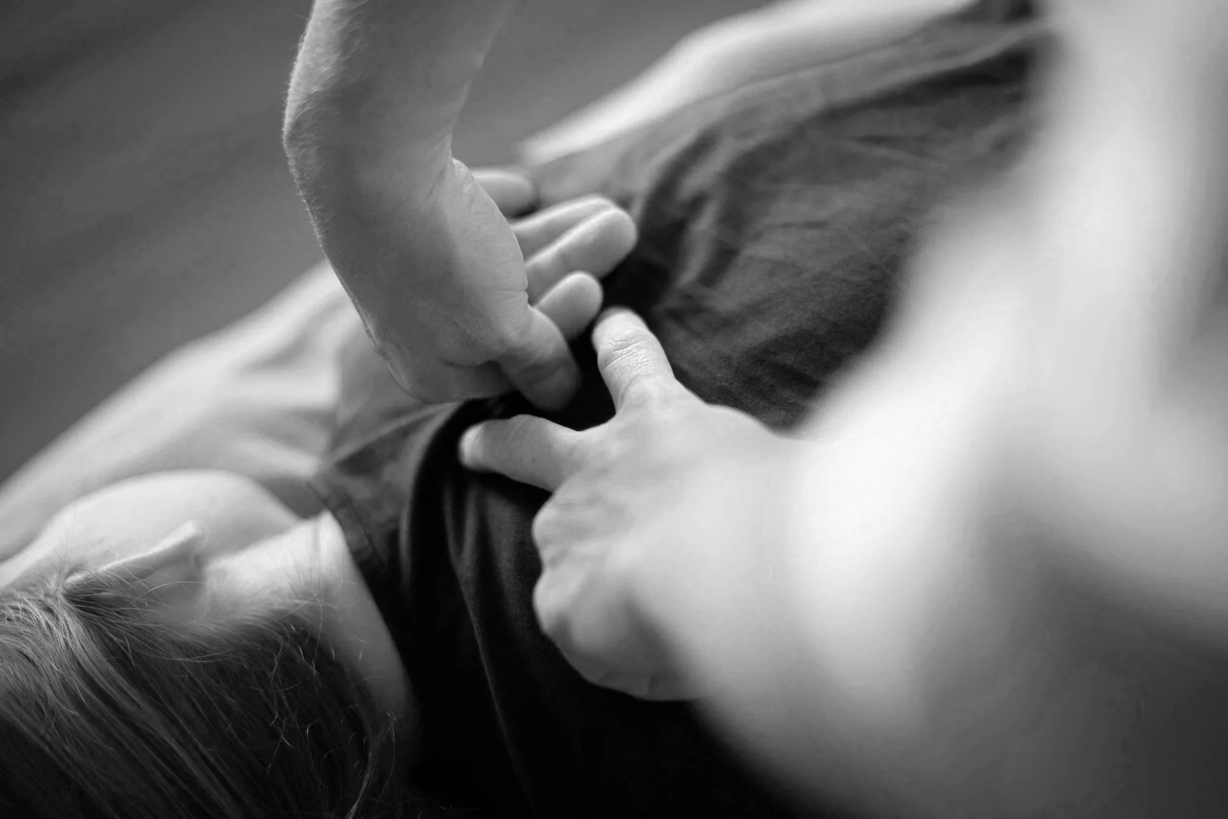 Osteopath treating a patient's upper back using manual therapy