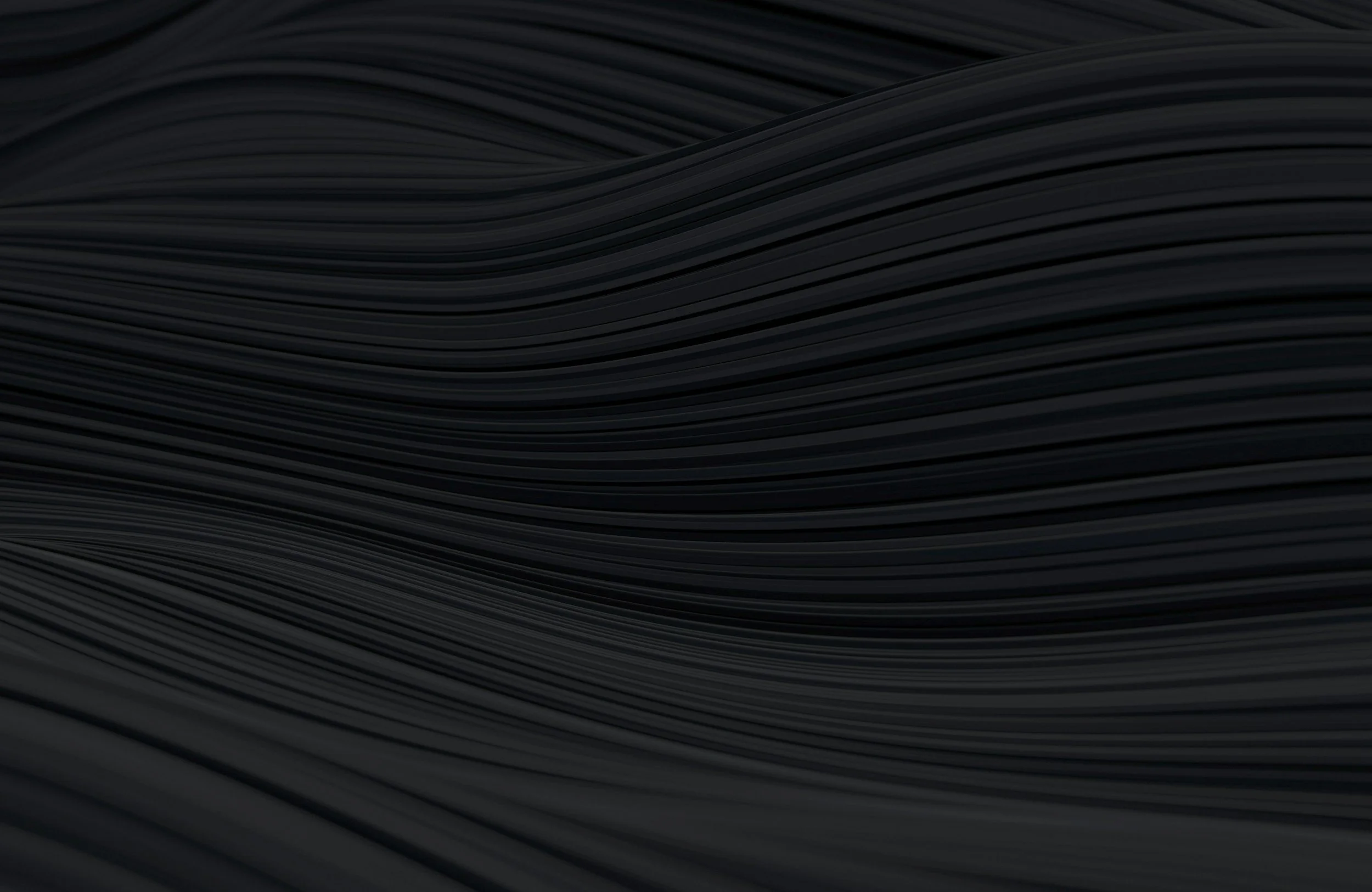 Close-up image of black, wavy textured material or surface, with curving parallel lines.