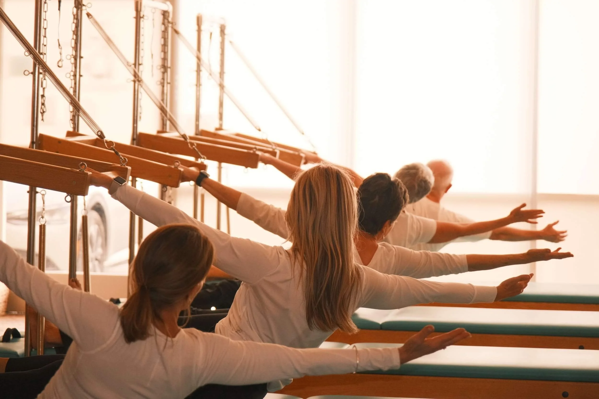 Group of people doing stretching exercises in a gym using resistance bands