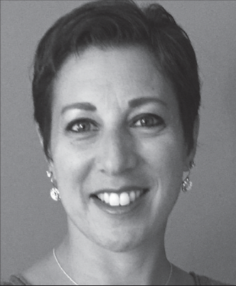 Black and white portrait of a woman smiling, with short hair and earrings.