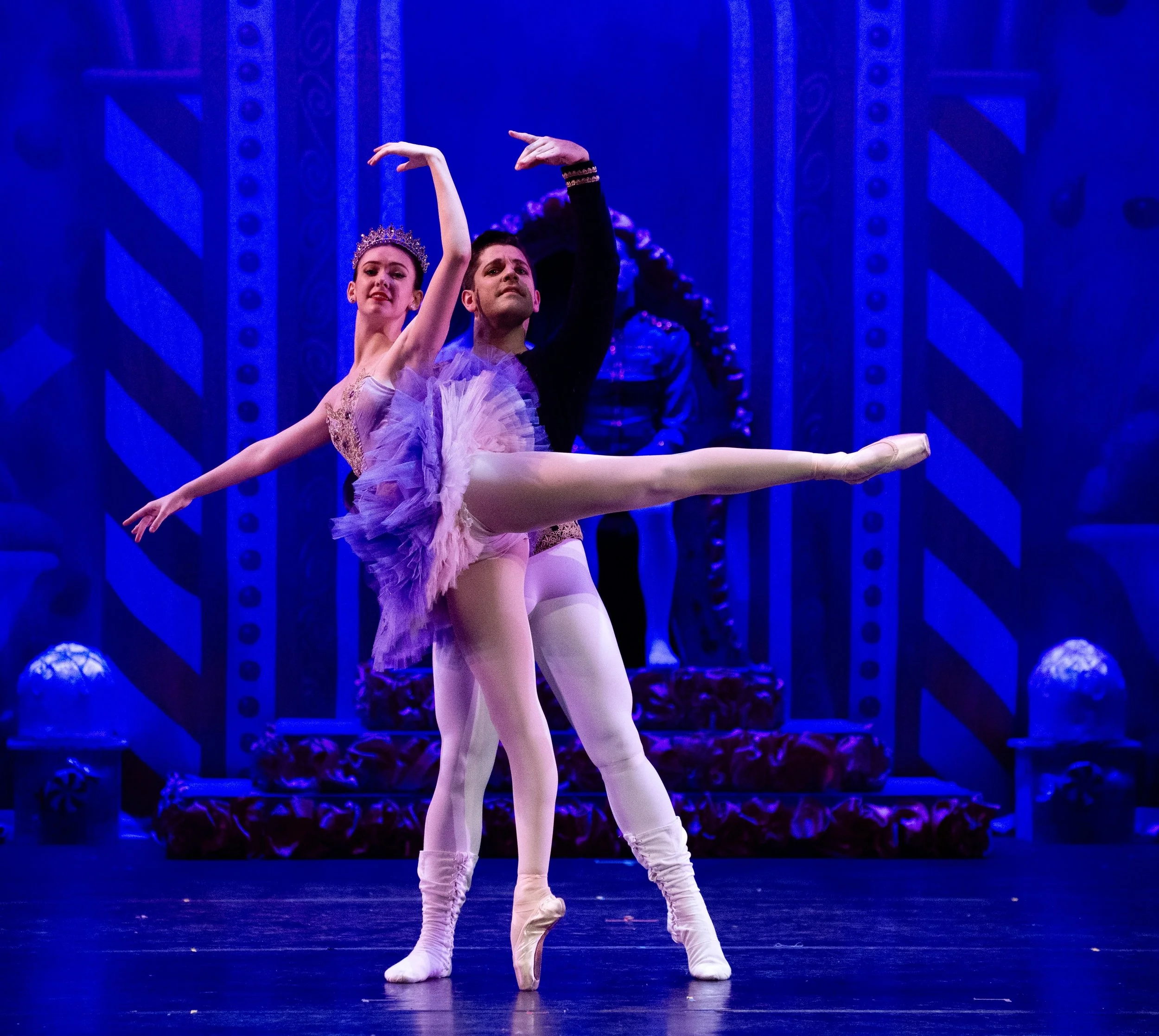 Two ballet dancers performing on stage, with a background resembling a royal or fantasy castle, featuring a throne and ornate decorations.