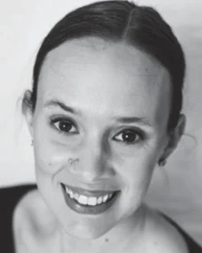 A black-and-white photo of a smiling woman with her hair pulled back.