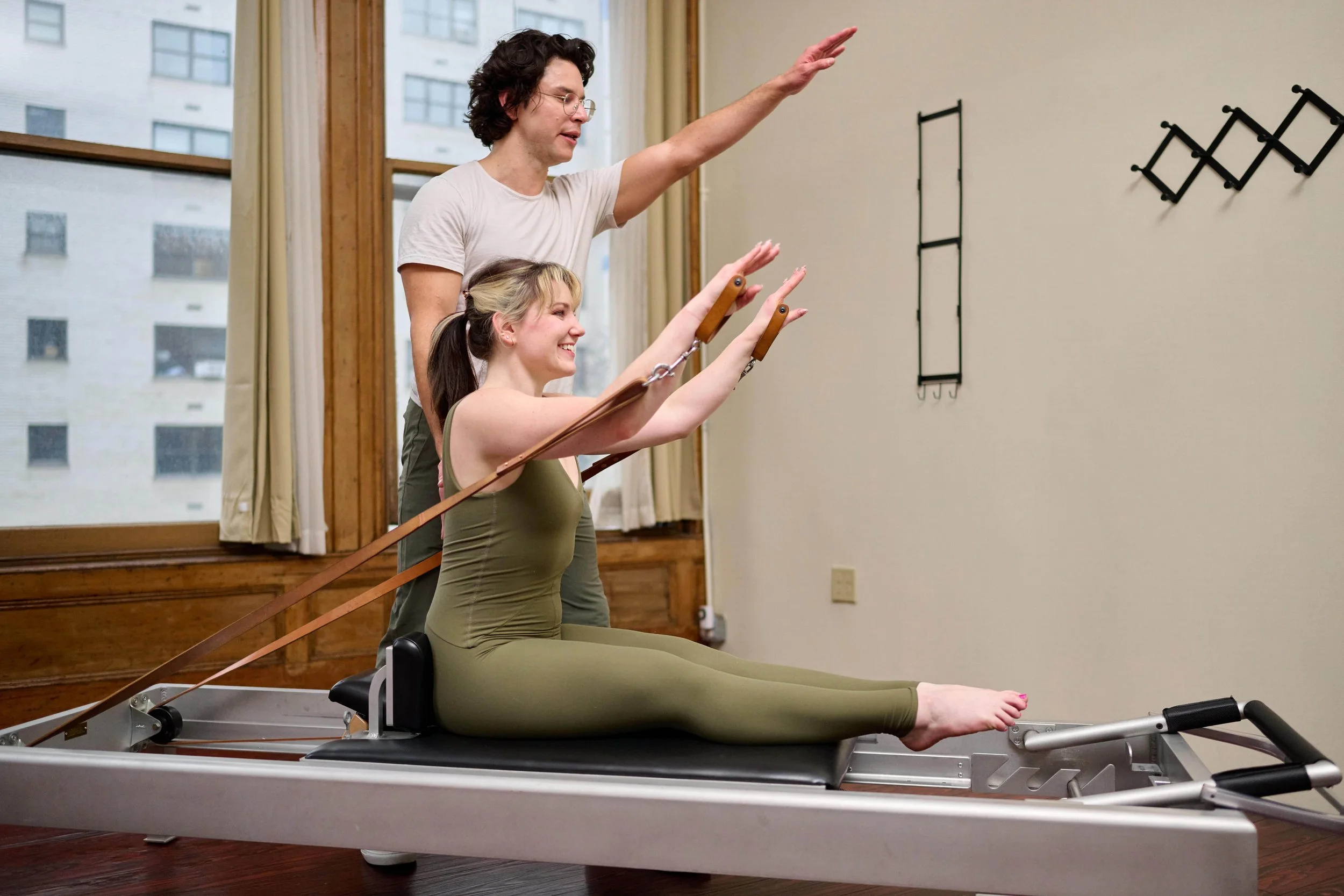 Cam working with student one on one on reformer in a private Pilates session
