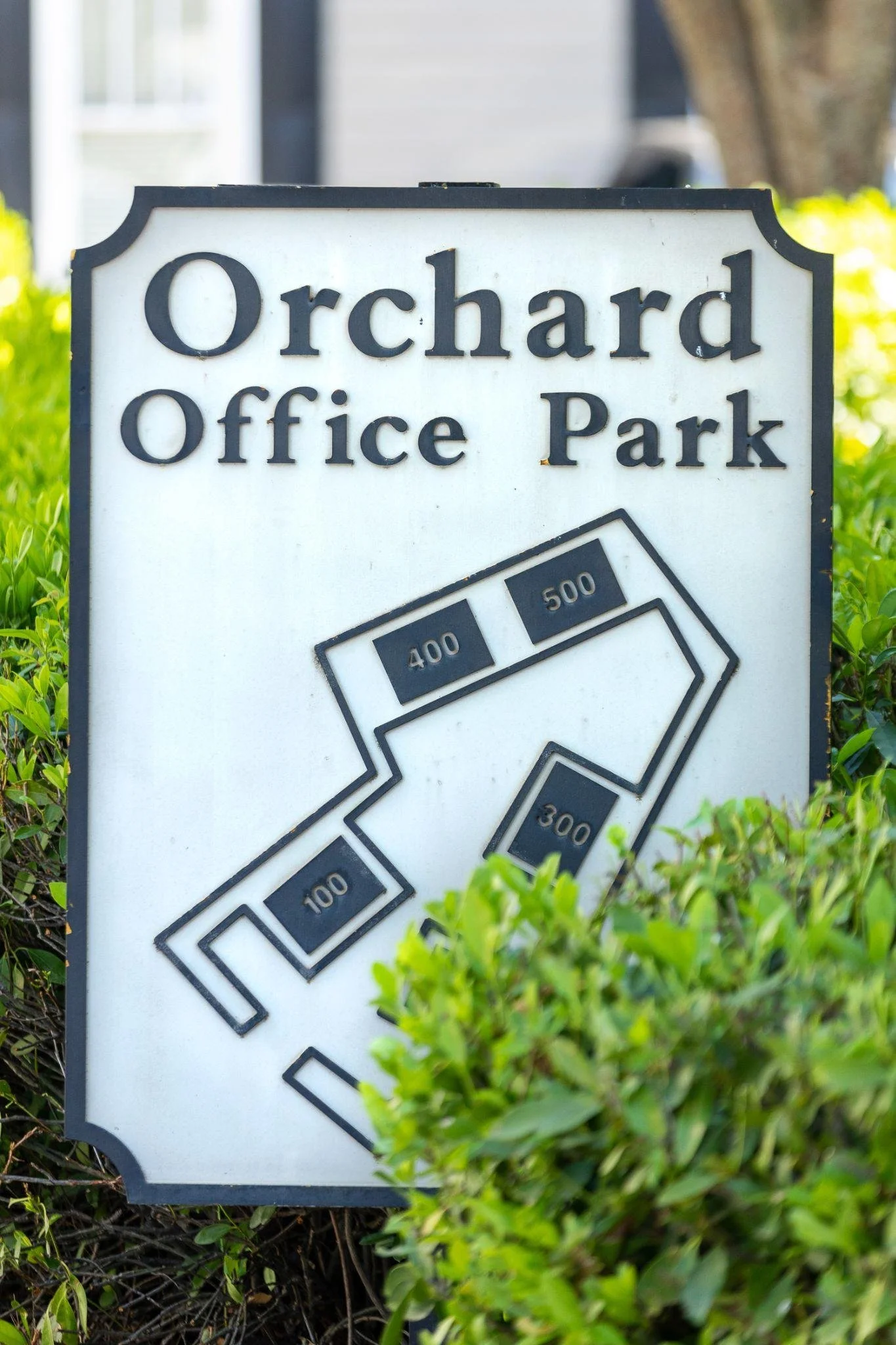 A sign for Orchard Office Park with a map showing distances from 100 to 500 units.