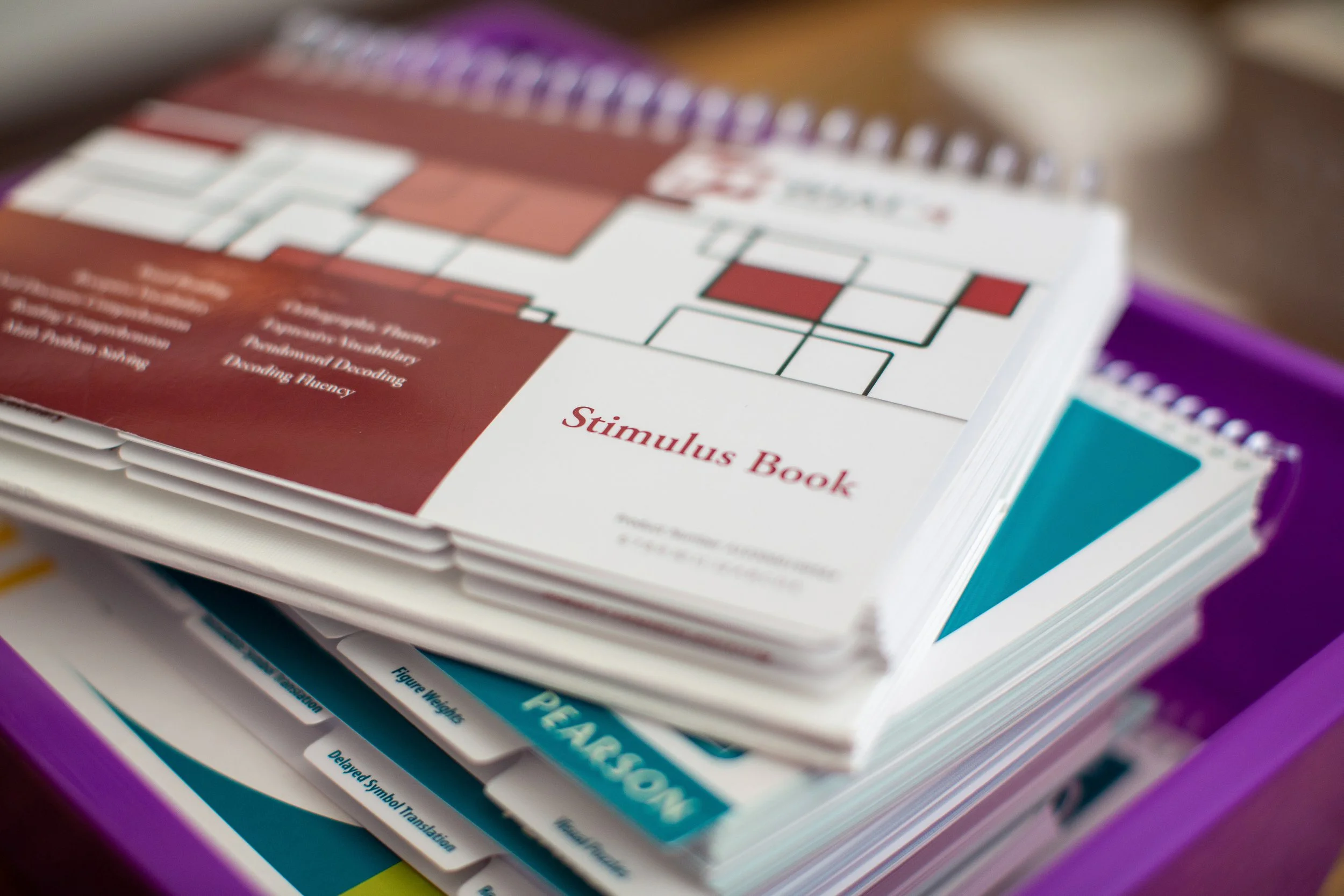 Close-up of a stack of educational books or workbooks with colorful tabs and highlighters, including a visible one labeled 'PERCENT'.