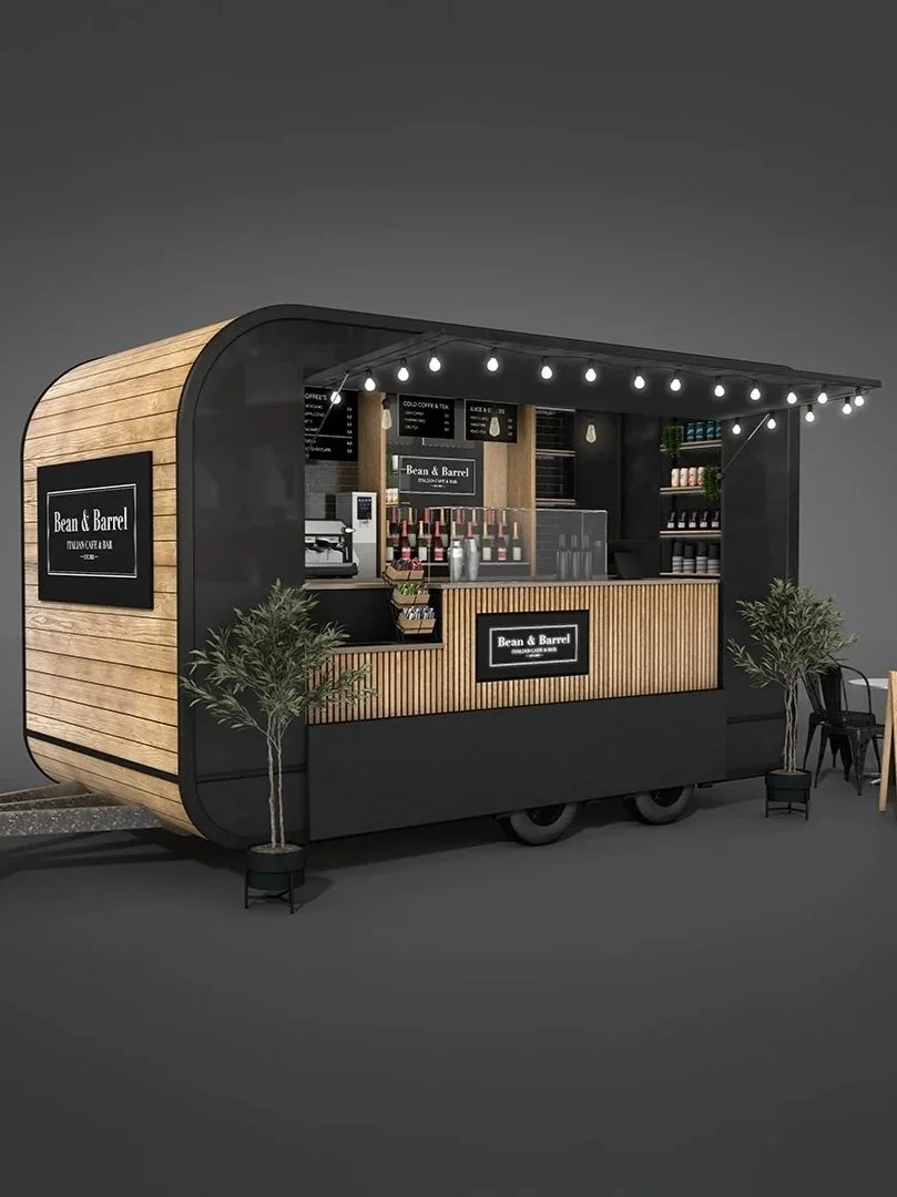 A modern coffee truck with wood paneling, black accents, and string lights, displaying a menu and bottles of wine, with plants and chairs nearby.