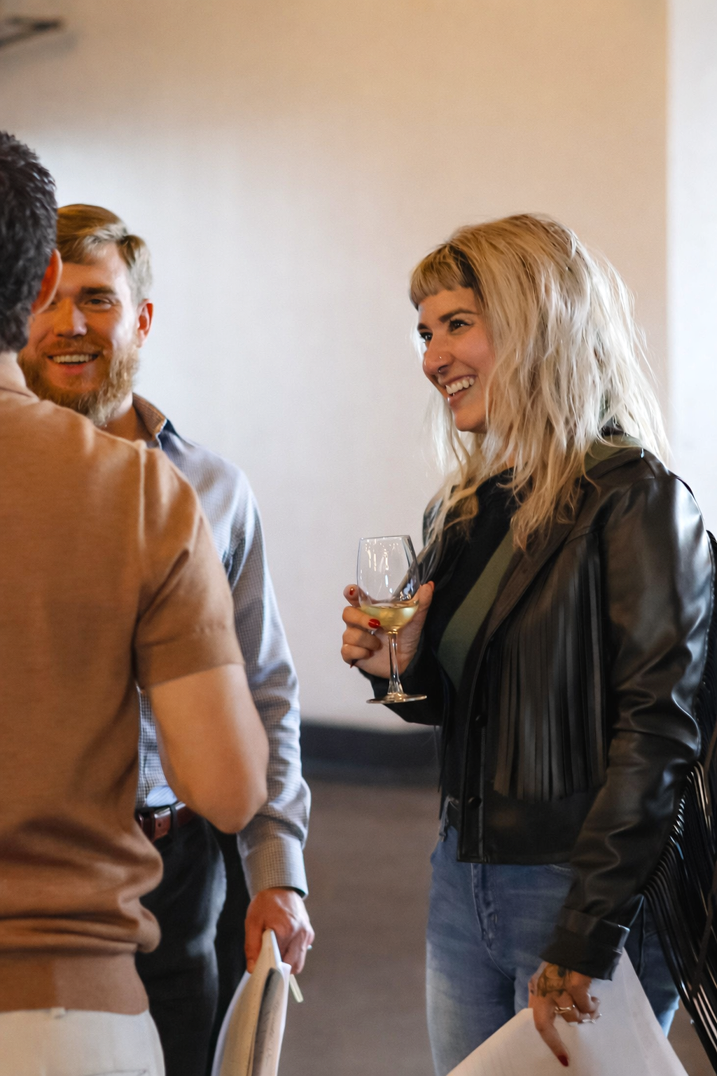 Guests mingling at a hosted event while enjoying wine in a venue setting, captured as candid on-site content for social media marketing.