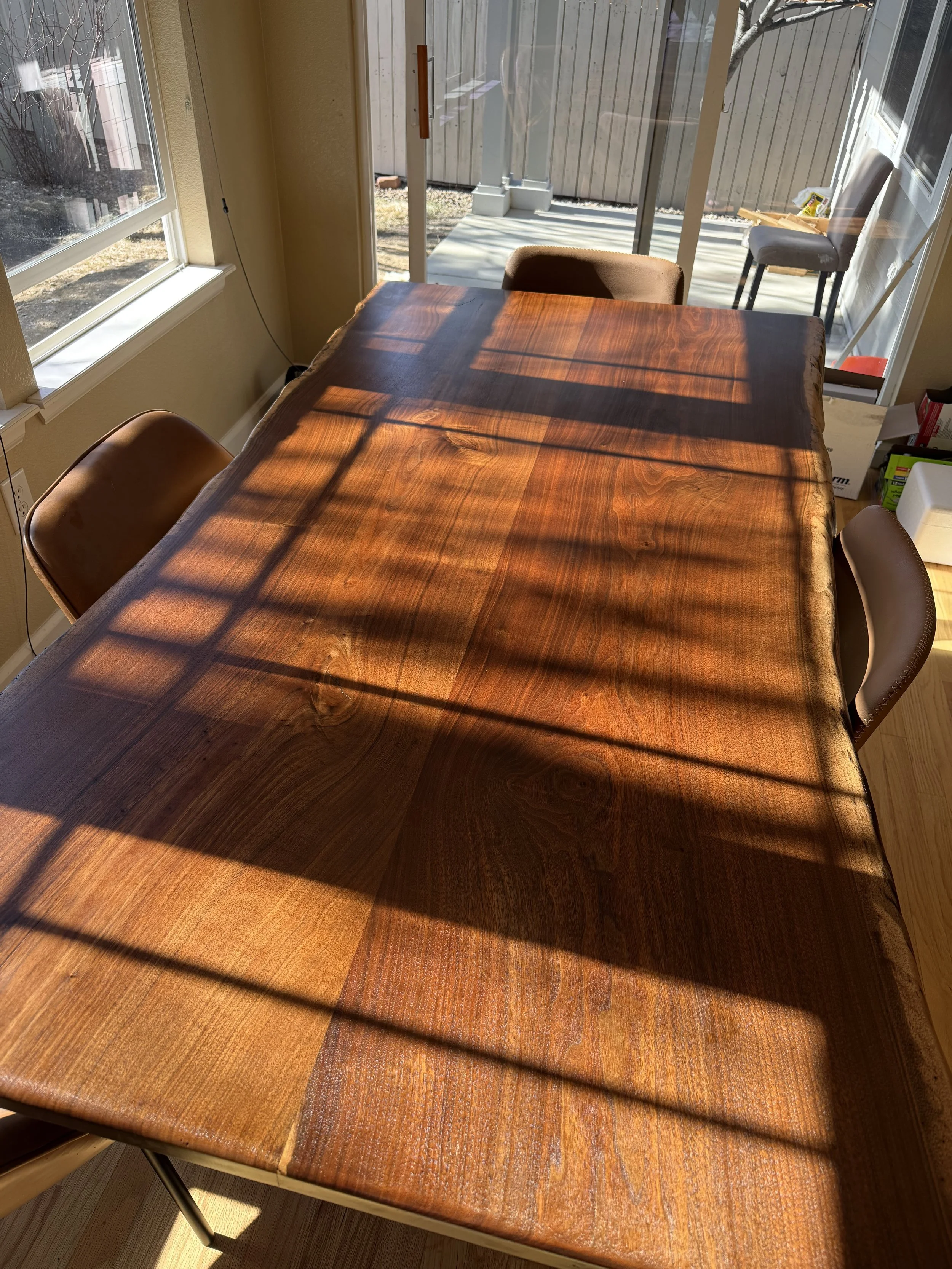 Walnut live edge dining table in the morning under the light of the rising sun