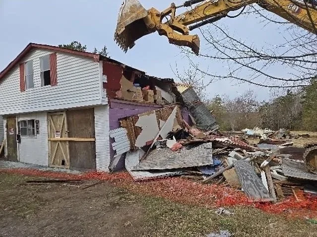 Excavator demolishing a two story building near Albemarle Virginia