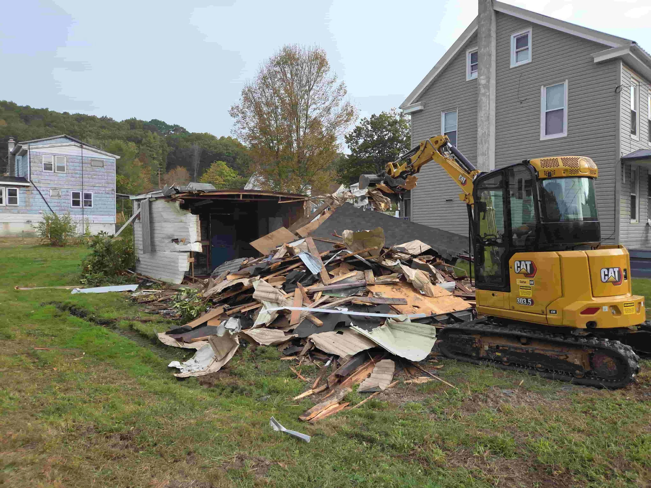 Excavator demolishing a garage