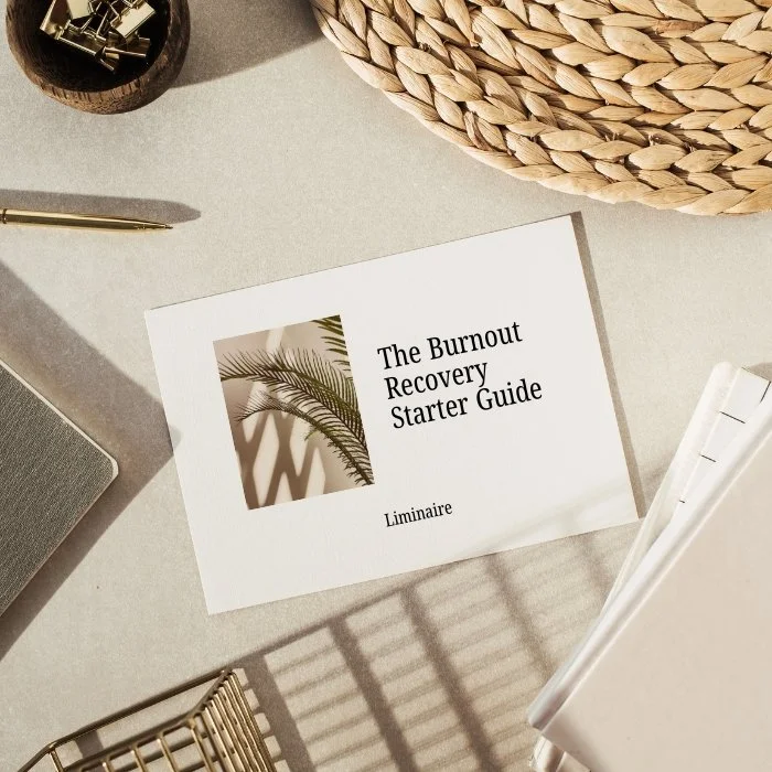 A desk with a starter guidebook titled 'The Burnout Recovery Starter Guide' on it, along with a notebook, pen, woven basket, and a gray container, all in a well-lit setting.