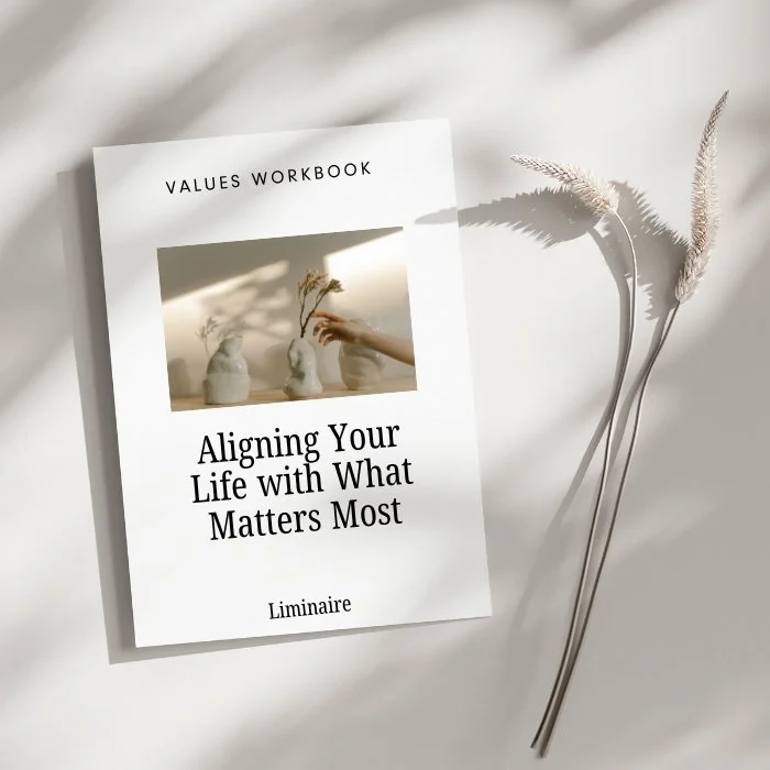 A values workbook titled "Aligning Your Life with What Matters Most" on a white surface with shadows and three dried plants beside it.