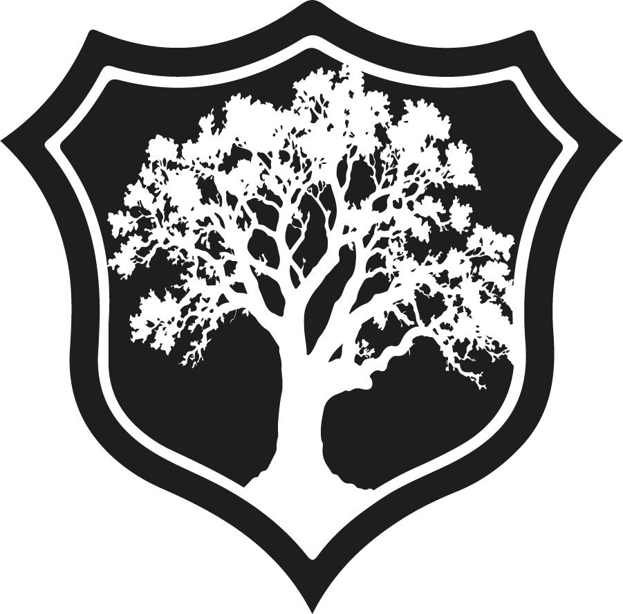 Silhouette of a large tree with many branches inside a shield-shaped outline.