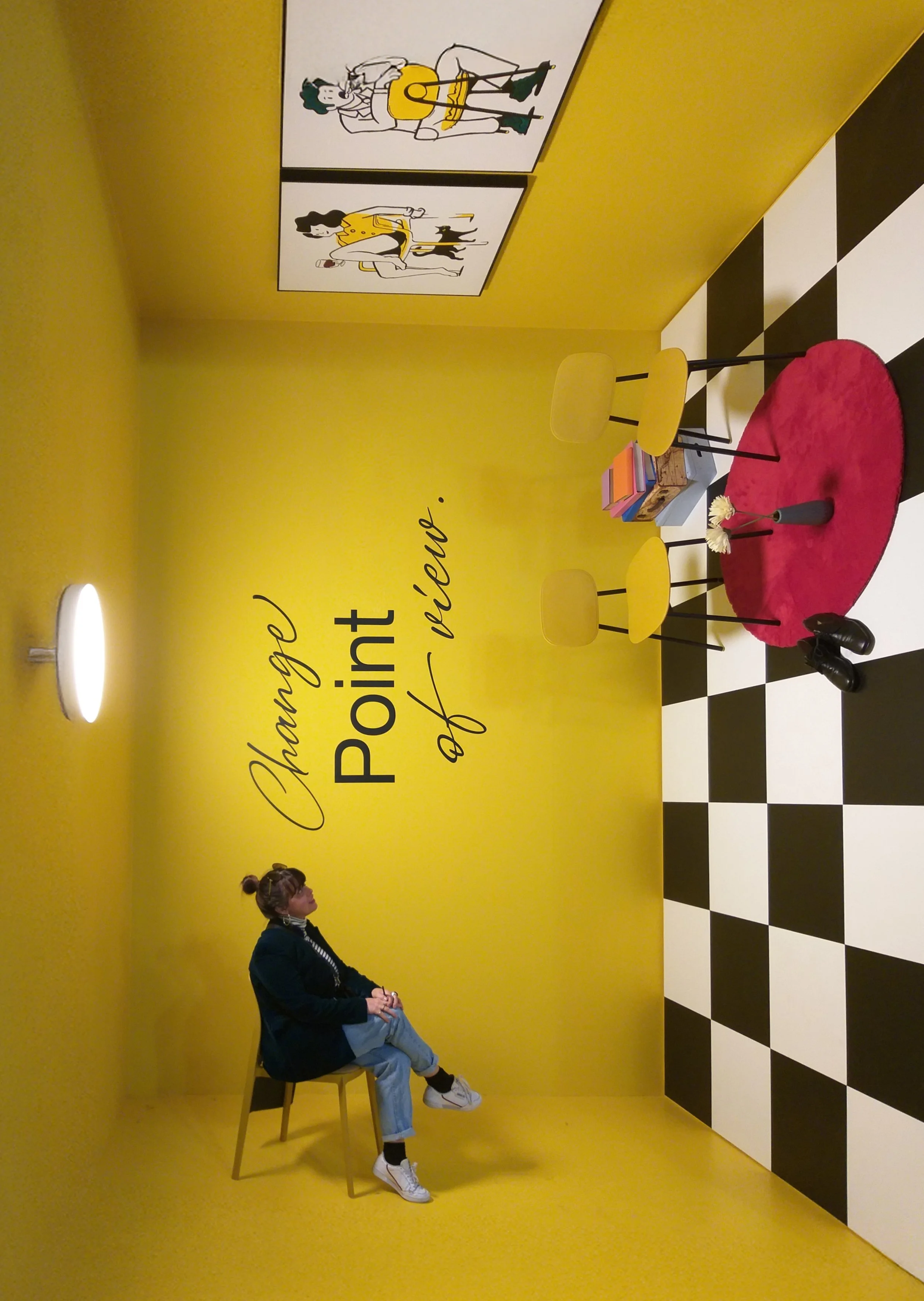 Interno di una stanza decorata con pareti gialle, un divano e quadri con illustrazioni di personaggi con chitarre. Scritto sulle pareti: 'Change Point of reunion'.