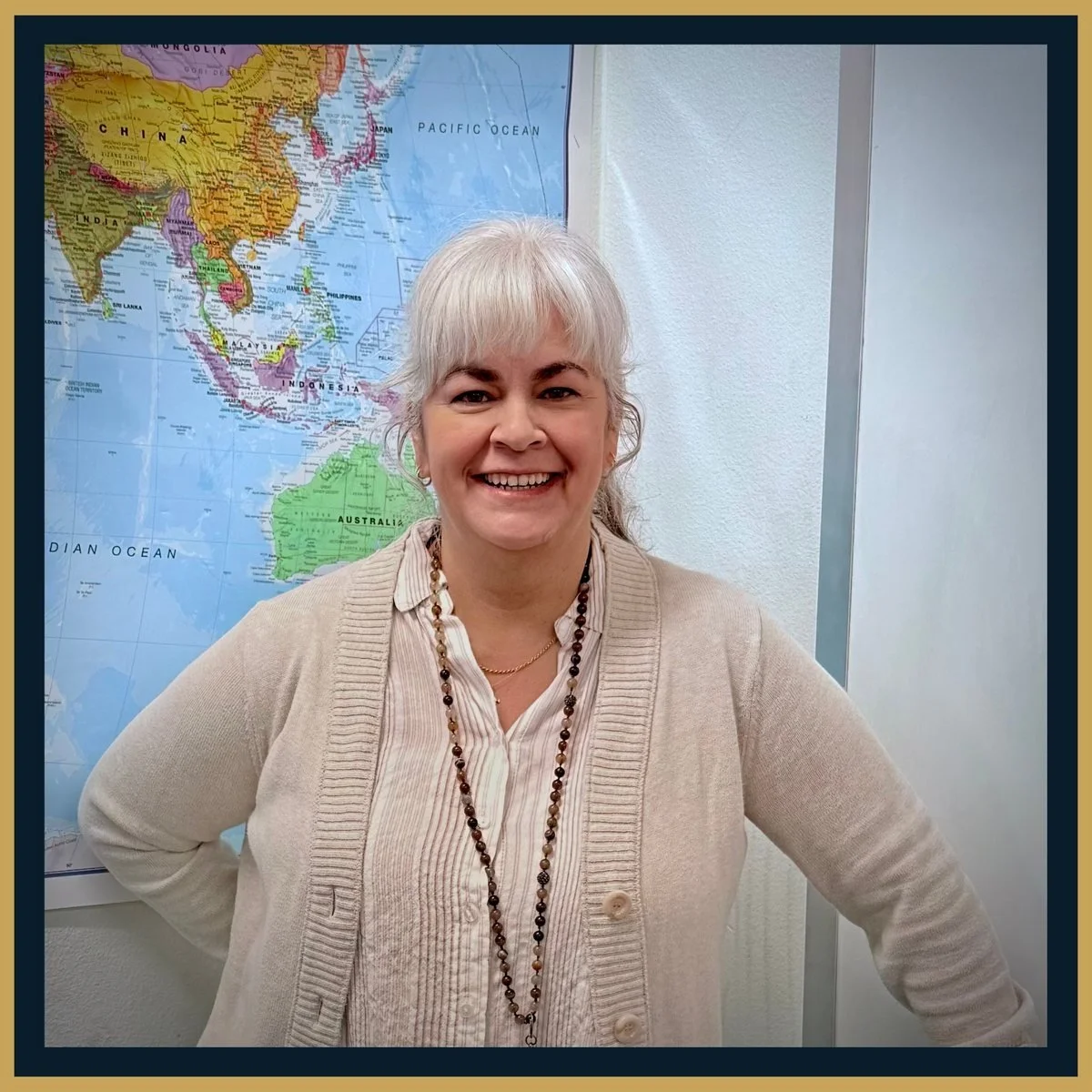 Angie Carraway in her classroom in front of a world map