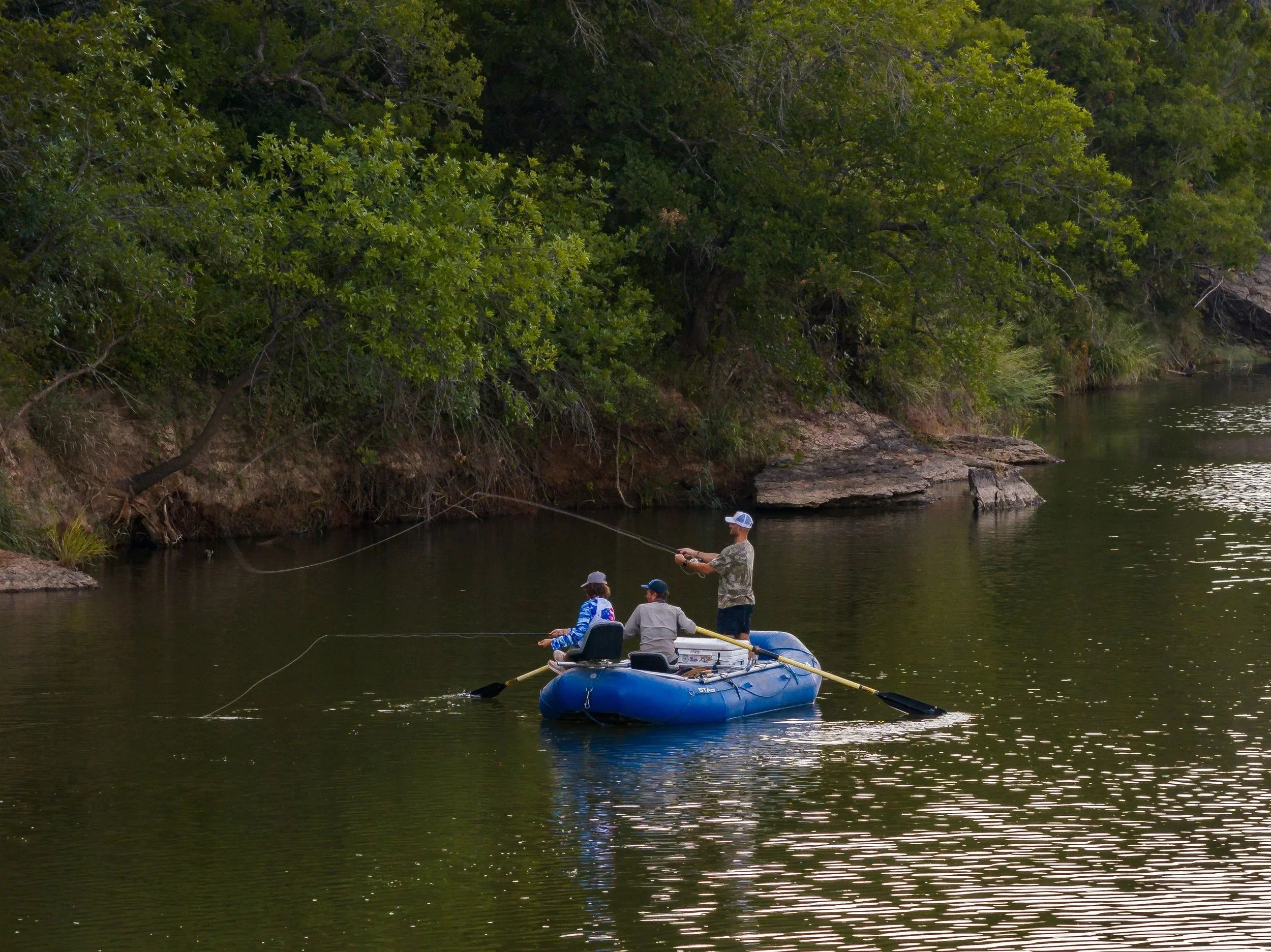 fisherman on a raft fishing in a river
