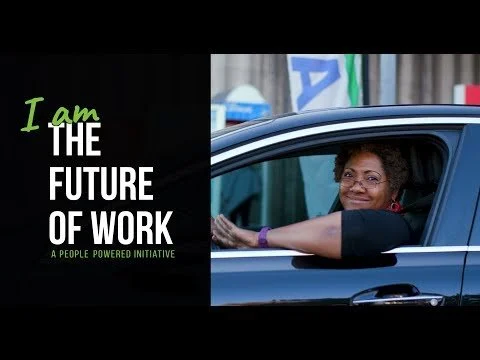 A woman smiling and pointing out of a car window, with a background of flags and a black and green graphic that says, 'I am the future of work, a people-powered initiative.'