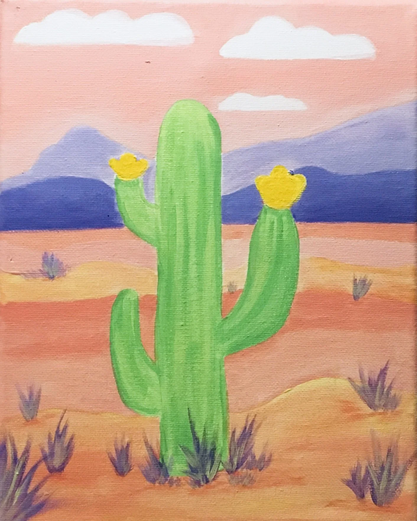 Painted desert scene with a green cactus with yellow flowers, purple mountains, orange sand, purple and yellow shrubs, and a pink sky with white clouds.