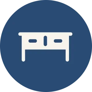 Icon of a white desk with a side drawer on a dark blue circular background.