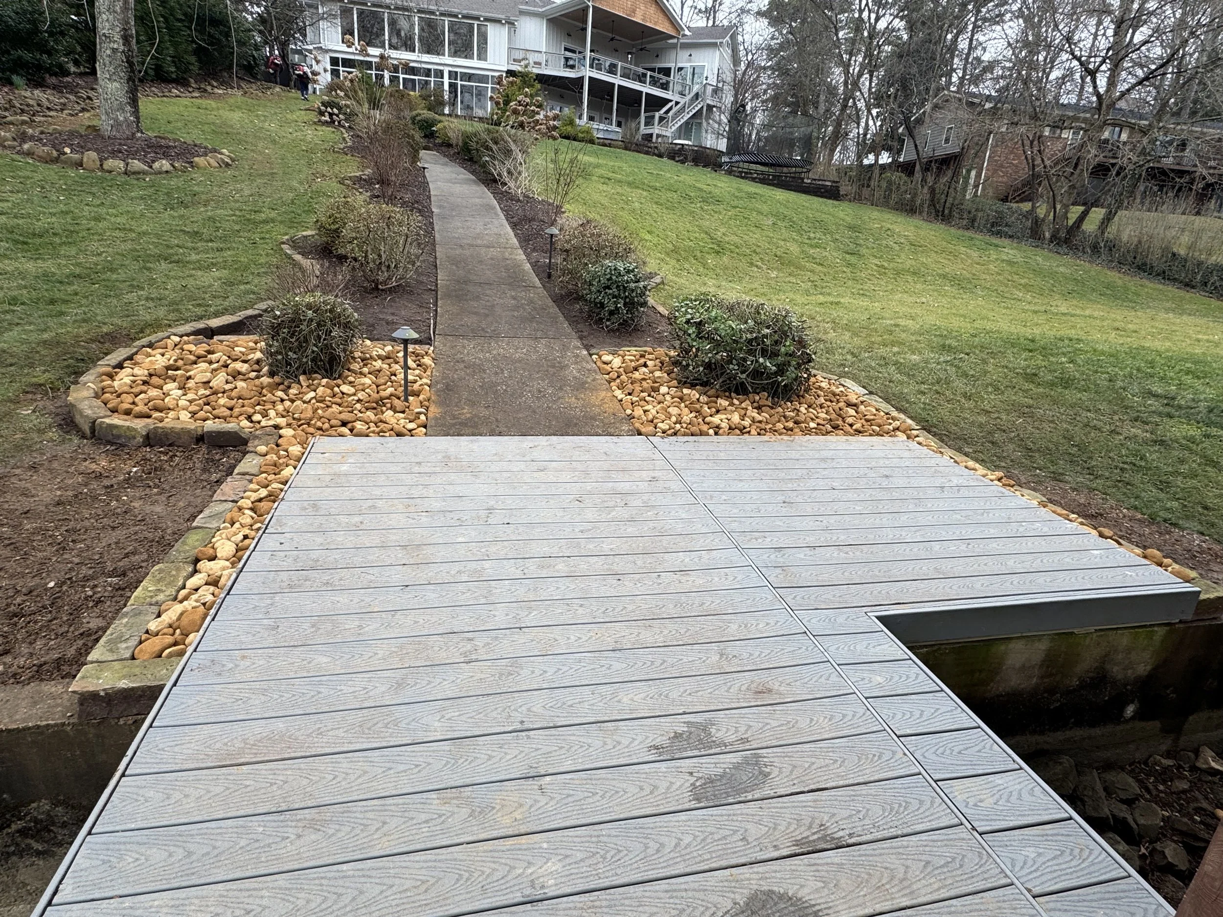 Backyard landscape renovation with stone features and newly shaped lawn areas.