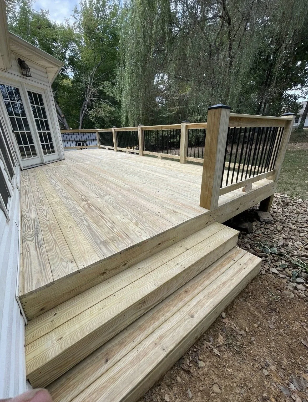 Newly constructed deck with stairs and railing. Perfect for outdoor living space expansion.