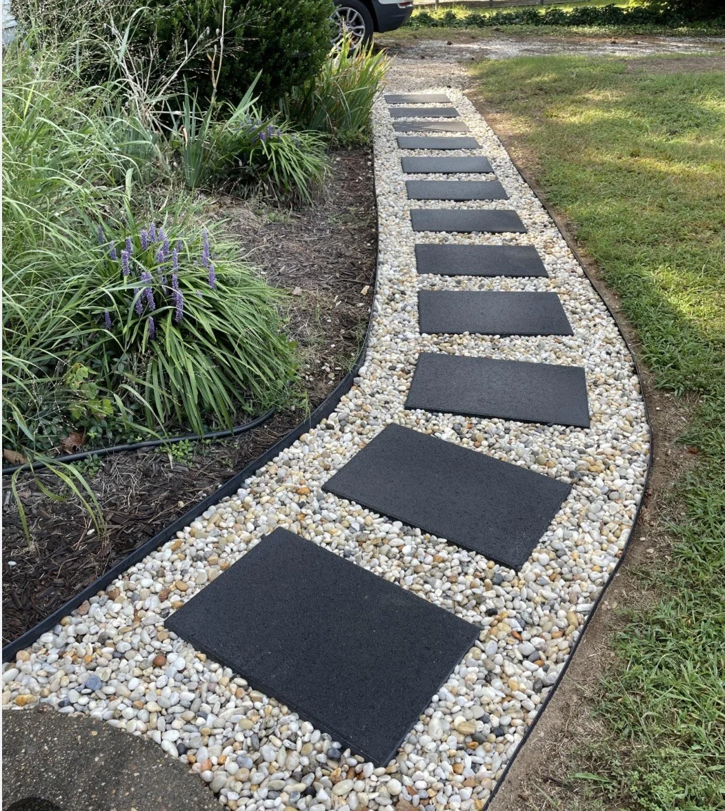 Custom stone walkway with modern stepping slabs set in decorative gravel for a sleek, low-maintenance path.
