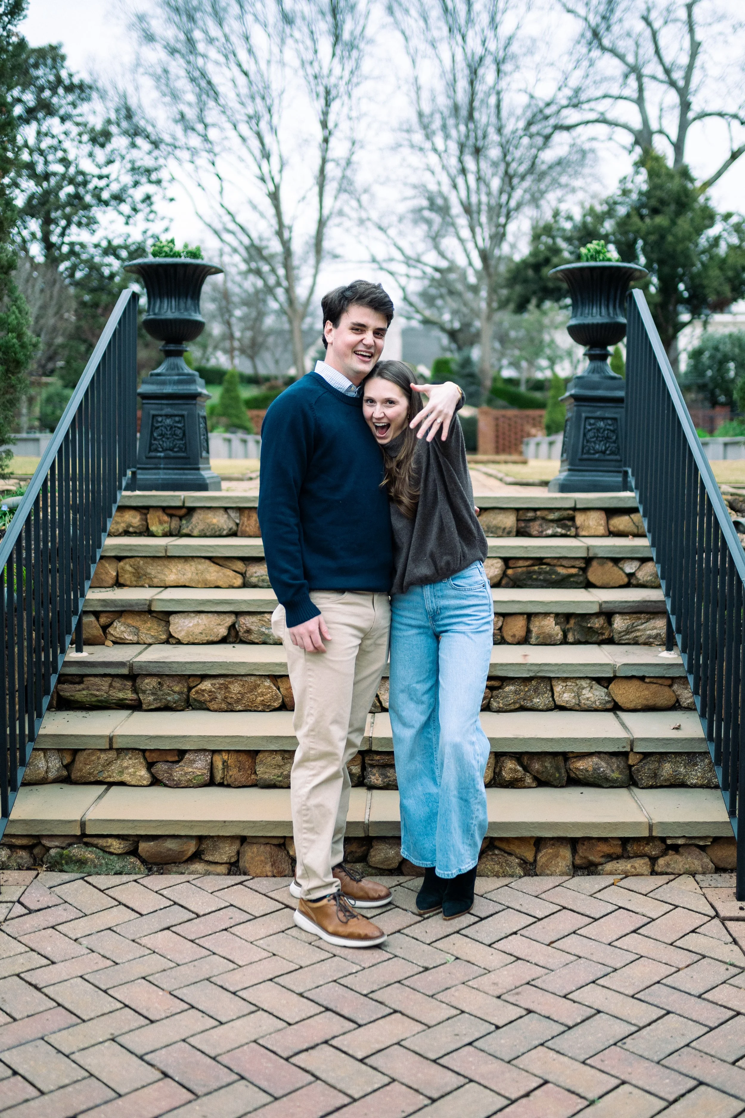 A young couple standing on steps outdoors, smiling and having fun.